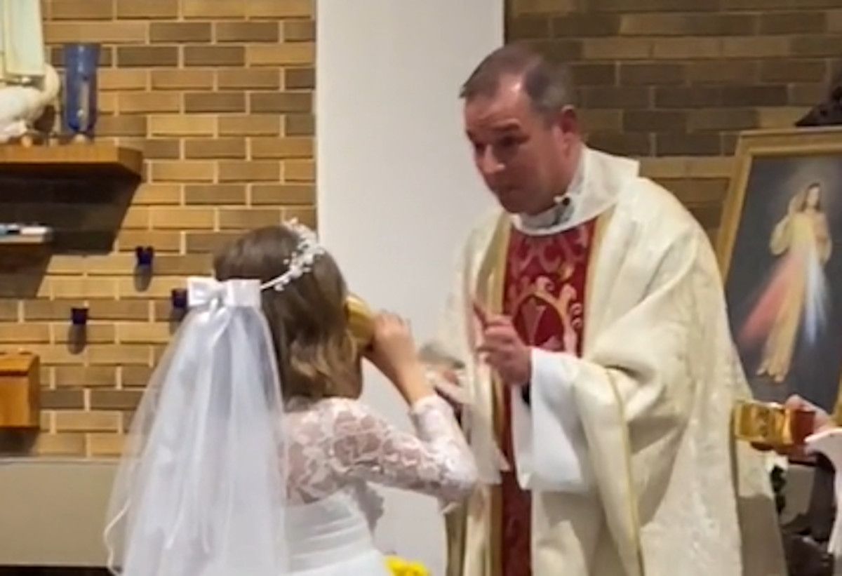 Una niña se bebe todo el vino en su primera comunión.