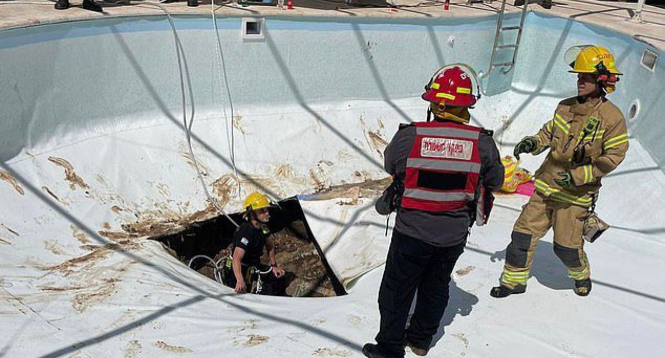 Bomberos tratando de rescatar al hombre que fue succionado por la piscina.