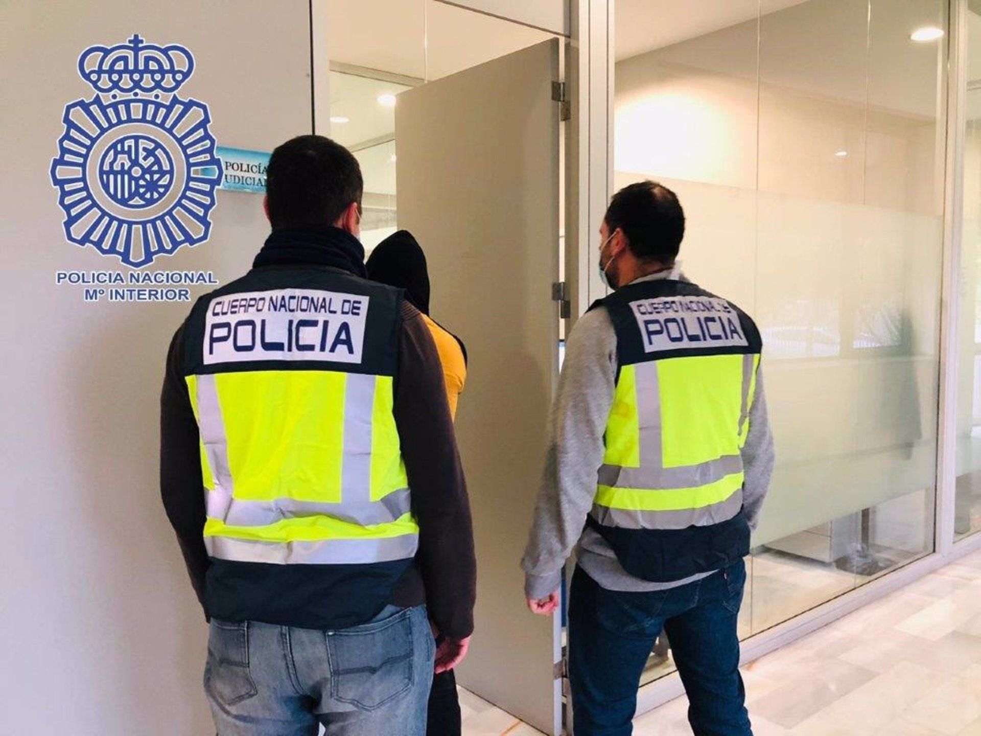 Retiene a su pareja tras partirle varias piezas dentales en su piso de Sevilla. Dos agentes de la Policía Nacional con un detenido, en una imagen de archivo.