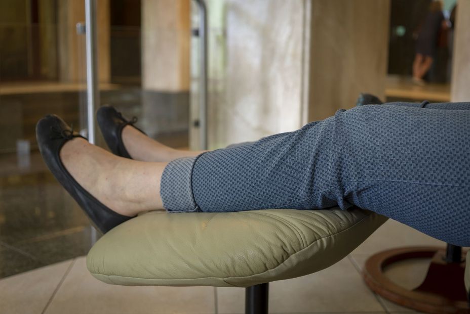 Una mujer con los pies en alto en una foto de archivo.  Así puedes evitar y prevenir las piernas hinchadas en verano