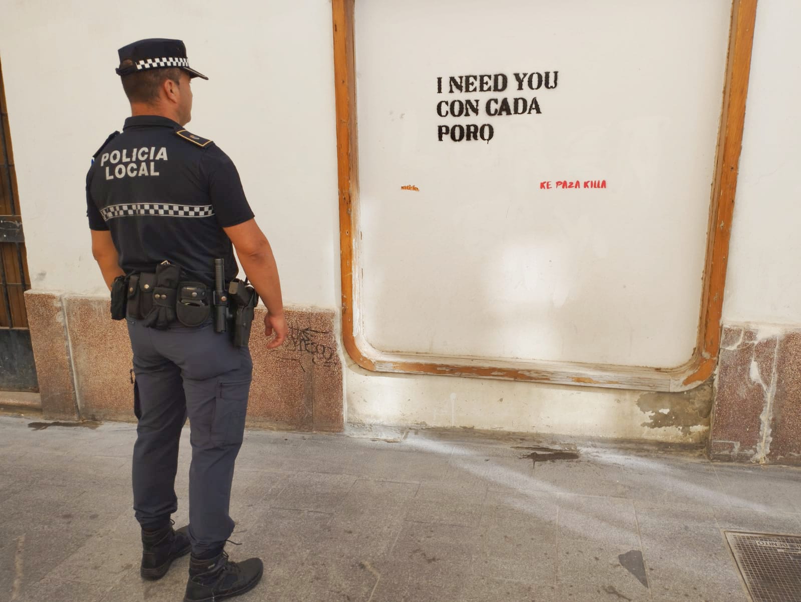 Un agente de Policía Local de El Puerto, delante de pintadas de la citada grafitera.