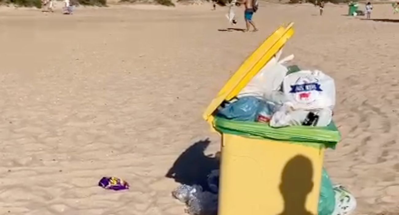 Contenedores llenos y bolsas de basura en la arena, en la playa de Bolonia. 