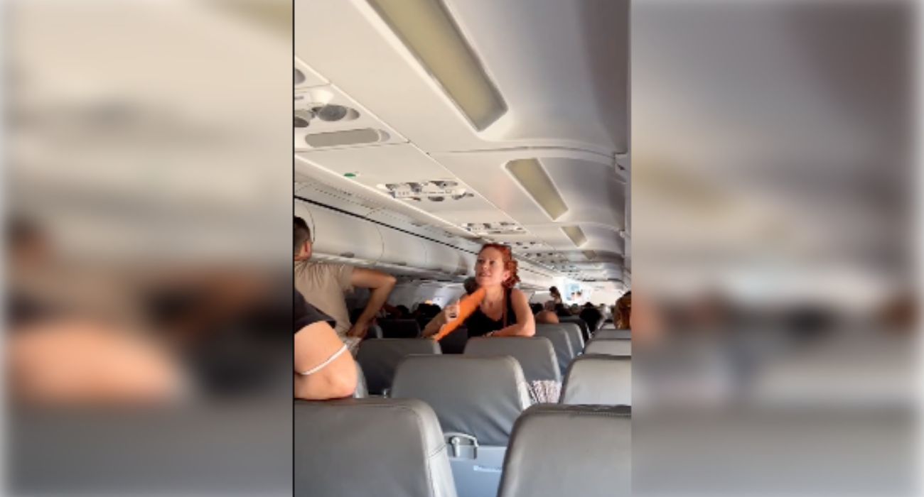 Una pasajera se abanica durante la espera dentro de un avión de Ryanair en el Aeropuerto de Sevilla.