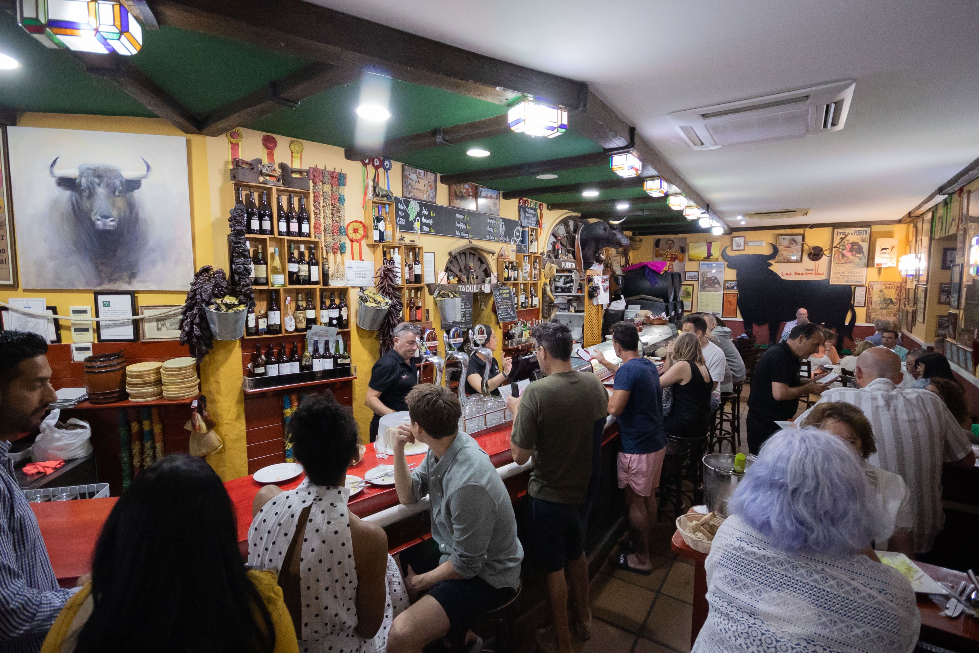 Interior del tabanco Las Banderillas, templo del tapeo en el centro de Jerez, casi siempre atestado de clientes.