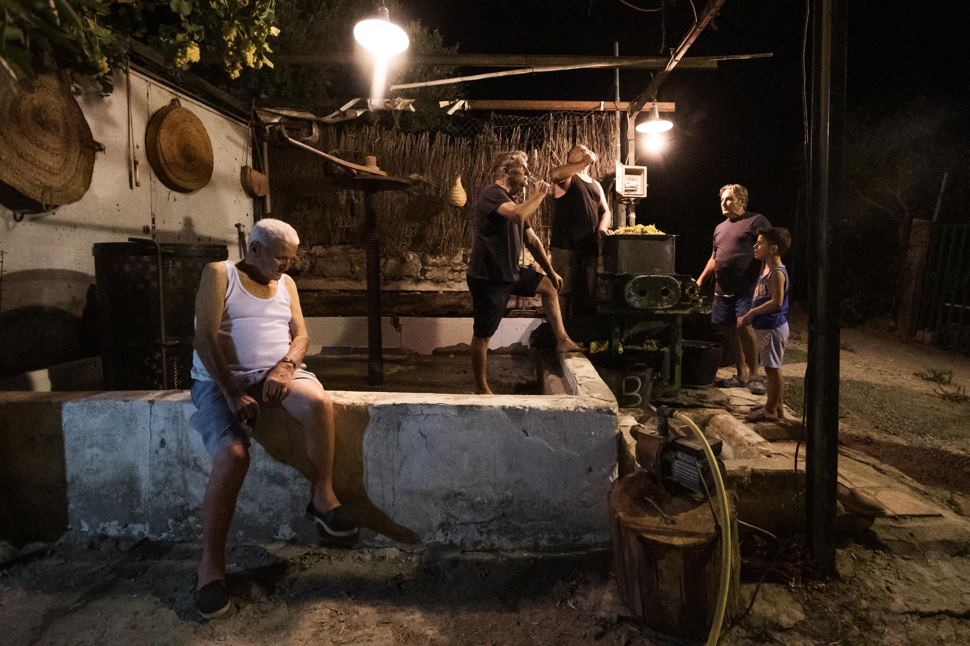 Paco Lara, sentado en el lagar, con sus hijos de fondo.