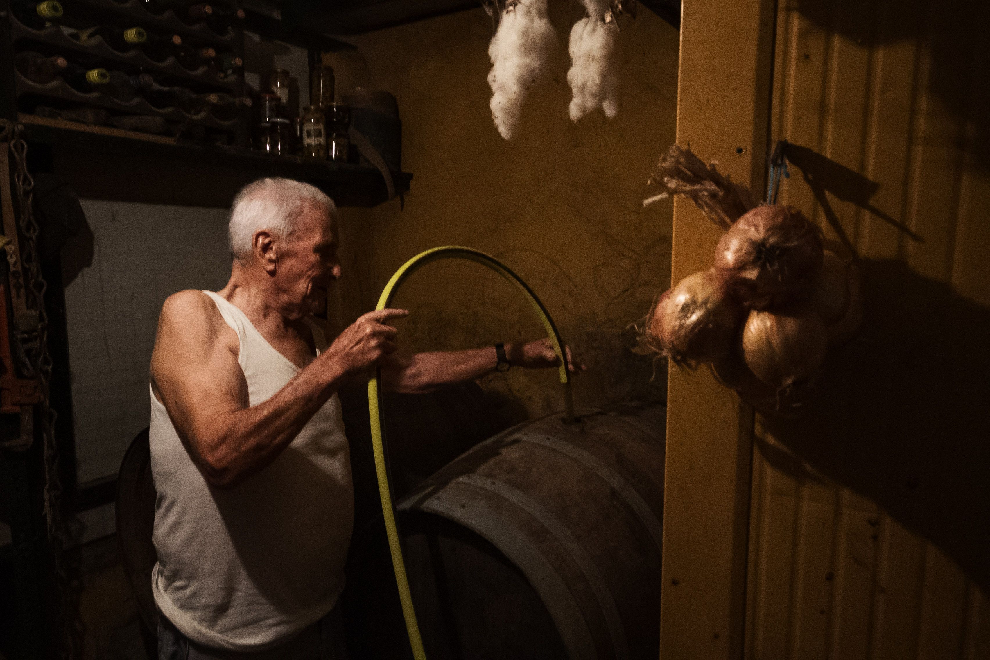 El cabeza de familia, llenando la bota con el caldo obtenido.