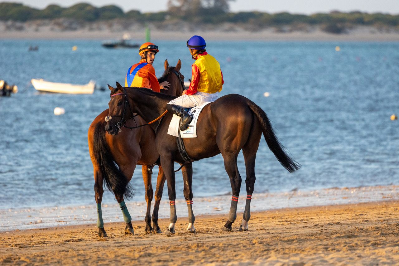 Dos jinetes hablan amistosamente en plena playa de Las Piletas.