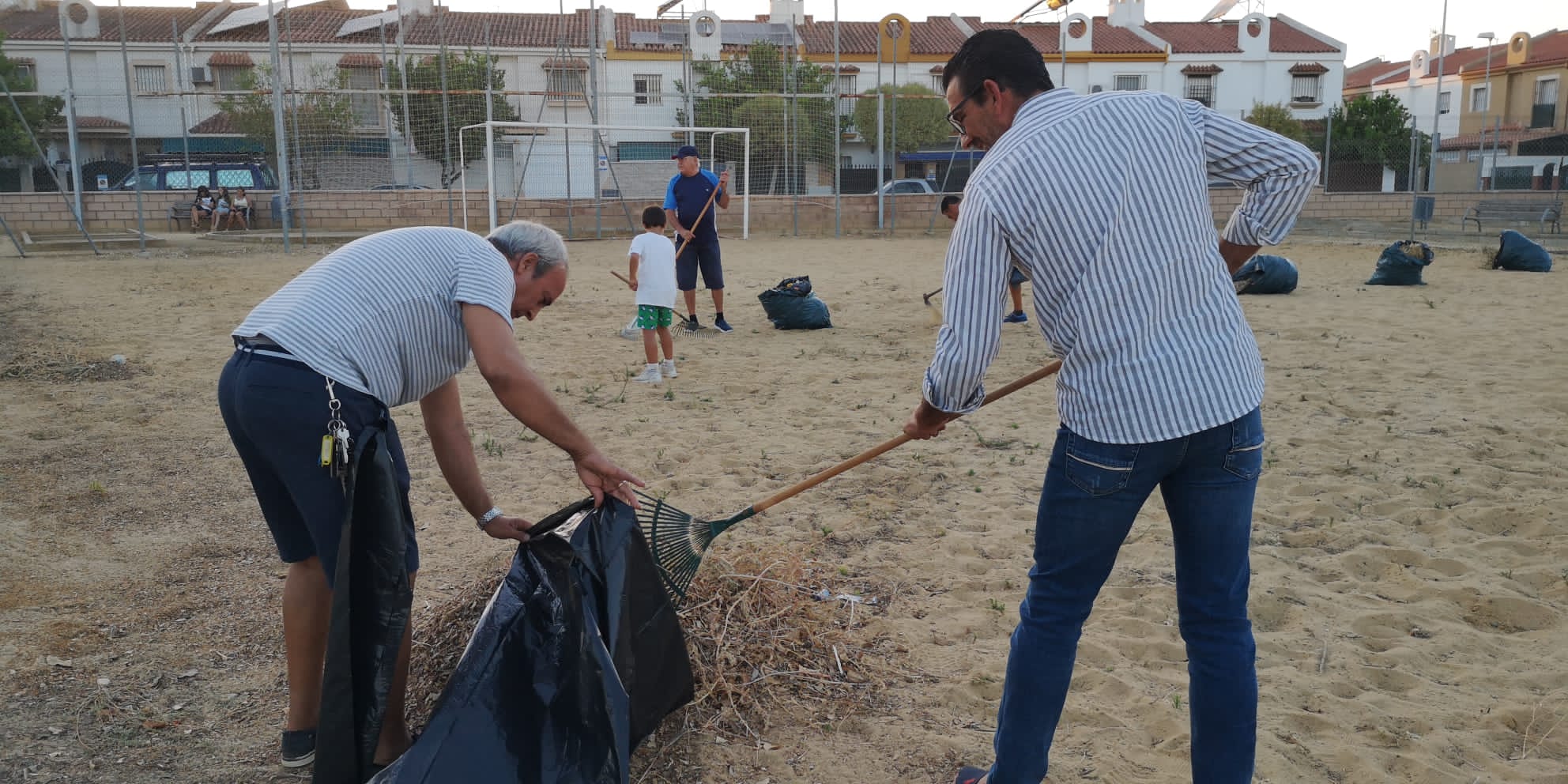 Vecinos de El Pinar y La Pita realizan labores de mantenimiento en la pista deportiva.