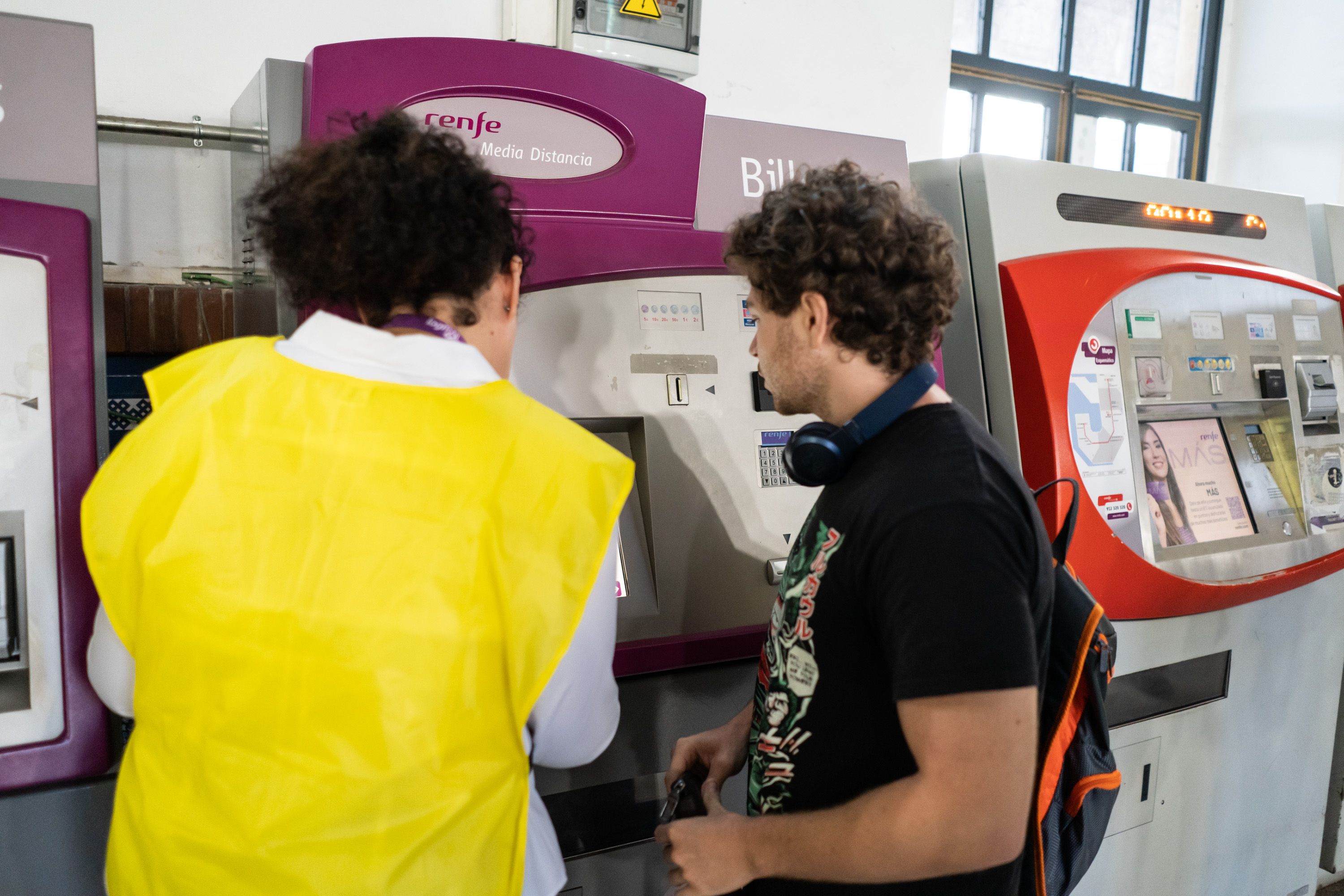 Una empleada de Renfe orienta a Daniel para usar su bono.