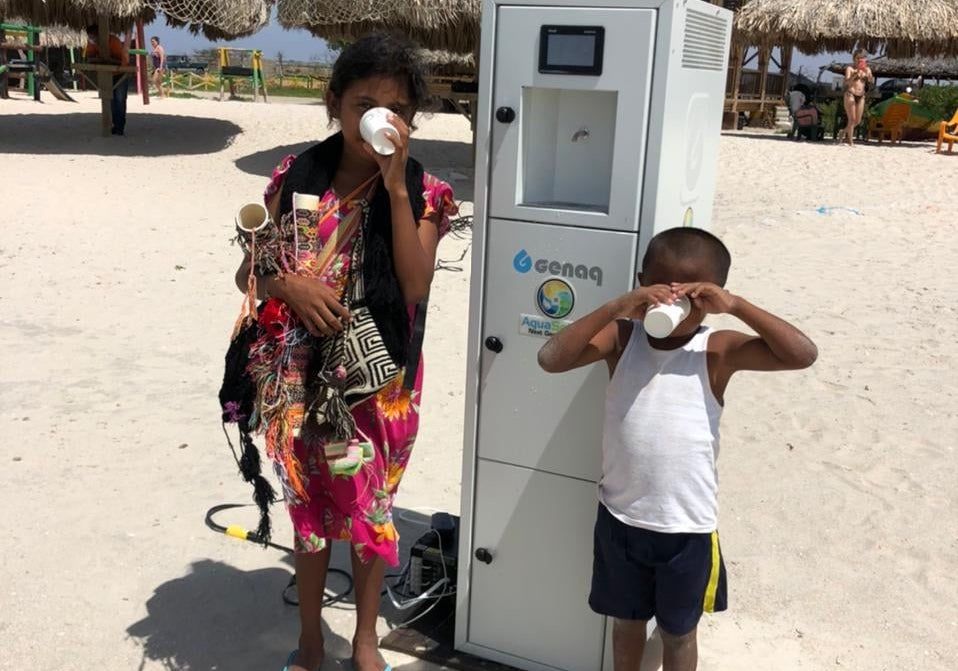 Niños bebiendo agua generada por la empresa cordobesa en Colombia.
