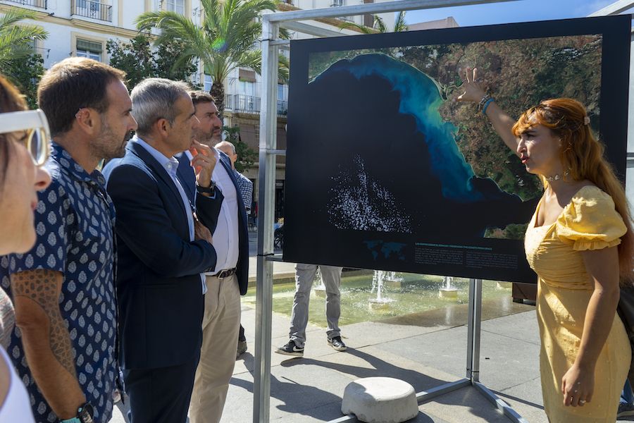 La comisaria de la exposición, Isabel Caballero, mostrando imágenes de zonas costeras captadas con satélites.