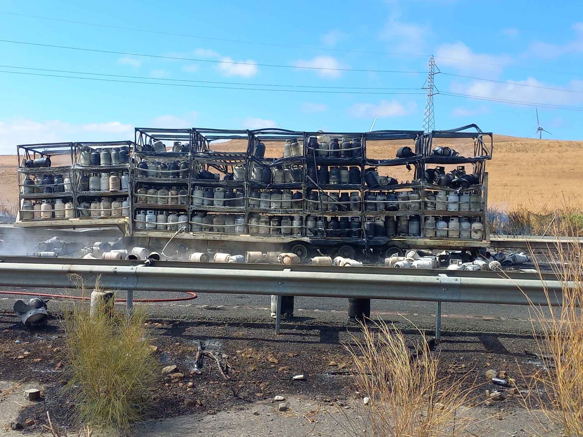 Estado en el que ha quedado el camión incendio, cargado de bombonas, a su paso por la A-381 Jerez-Los Barrios.