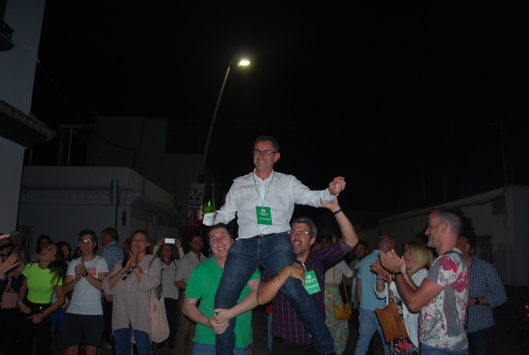 El alcalde de Barbate, Miguel Molina, champán en mano, aupado por la militancia de AxSí en la noche electoral del pasado domingo.