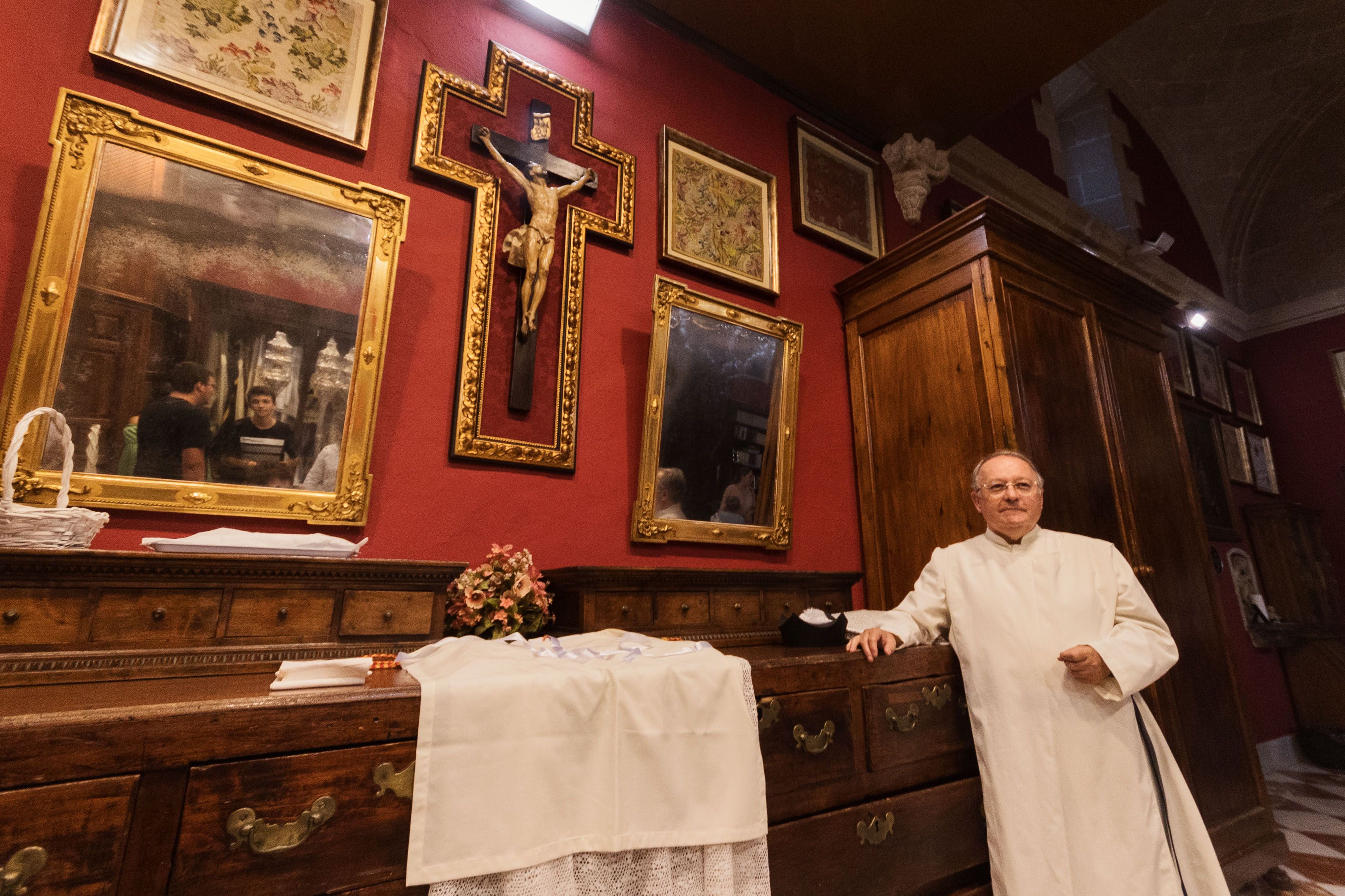 Felipe Ortuno posando en la sacristía donde cuelgan cuadros y exvotos con siglos de historia.    MANU GARCÍA