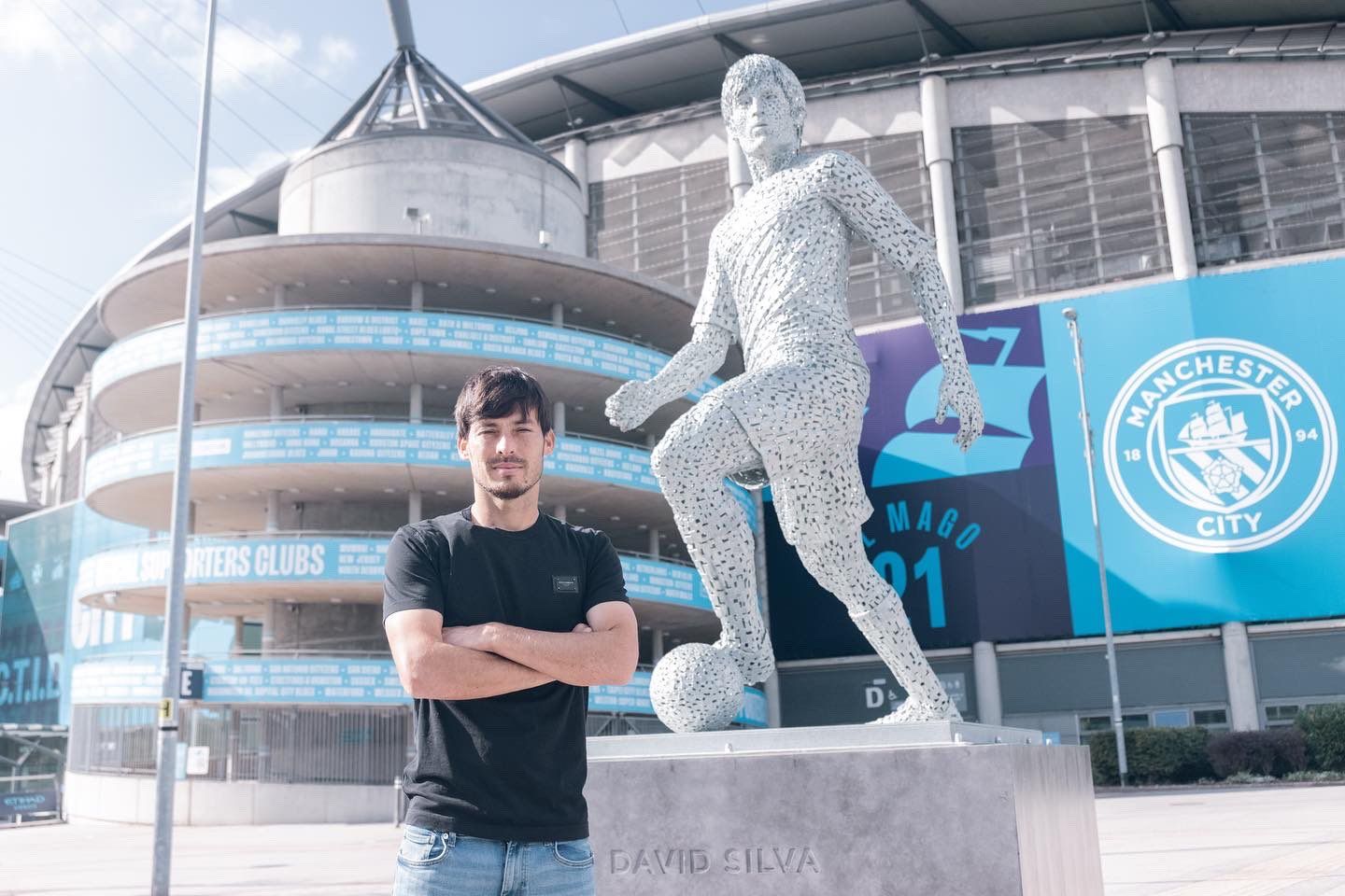 David Silva, junto a la estatua que tiene en los aledaños del campo del Manchester City.