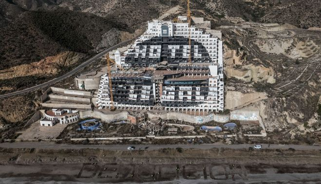 Activistas de Greenpeace escriben 'Demolición' ante el hotel El Algarrobico. GREENPEACE