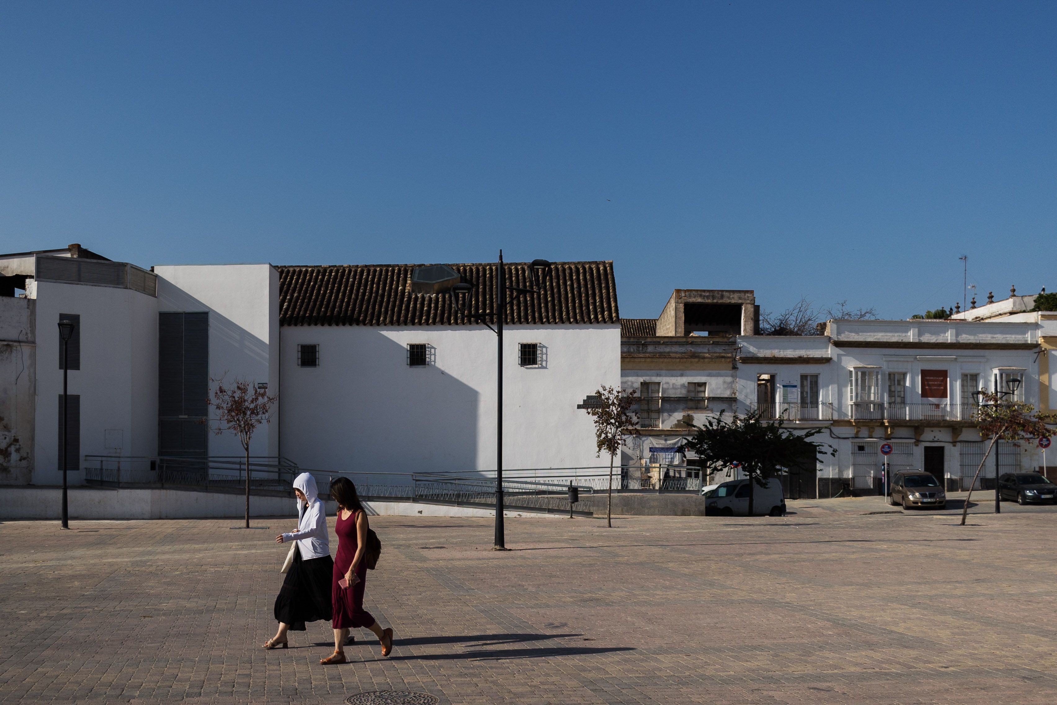 Dos viandantes cruzan, en días pasados, la plaza Belén, con la Nave del Aceite donde abrirá el Centro de Interpretación Lola Flores y, al fondo, la otra finca donde irá el tablao.