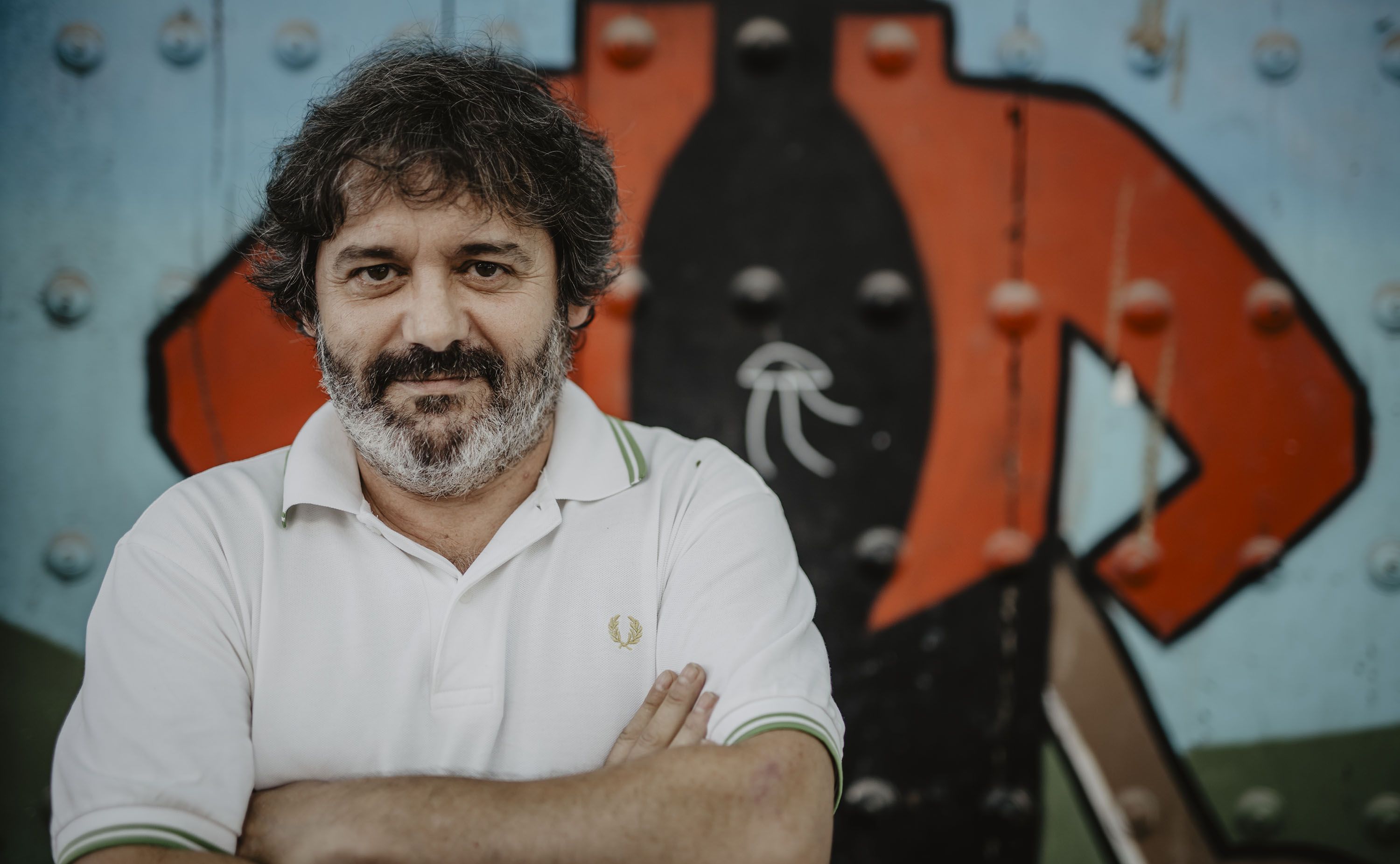 Atrevido y original; el cartelista de la Semana Santa ante un grafiti del Tío Pepe.    ESTEBAN