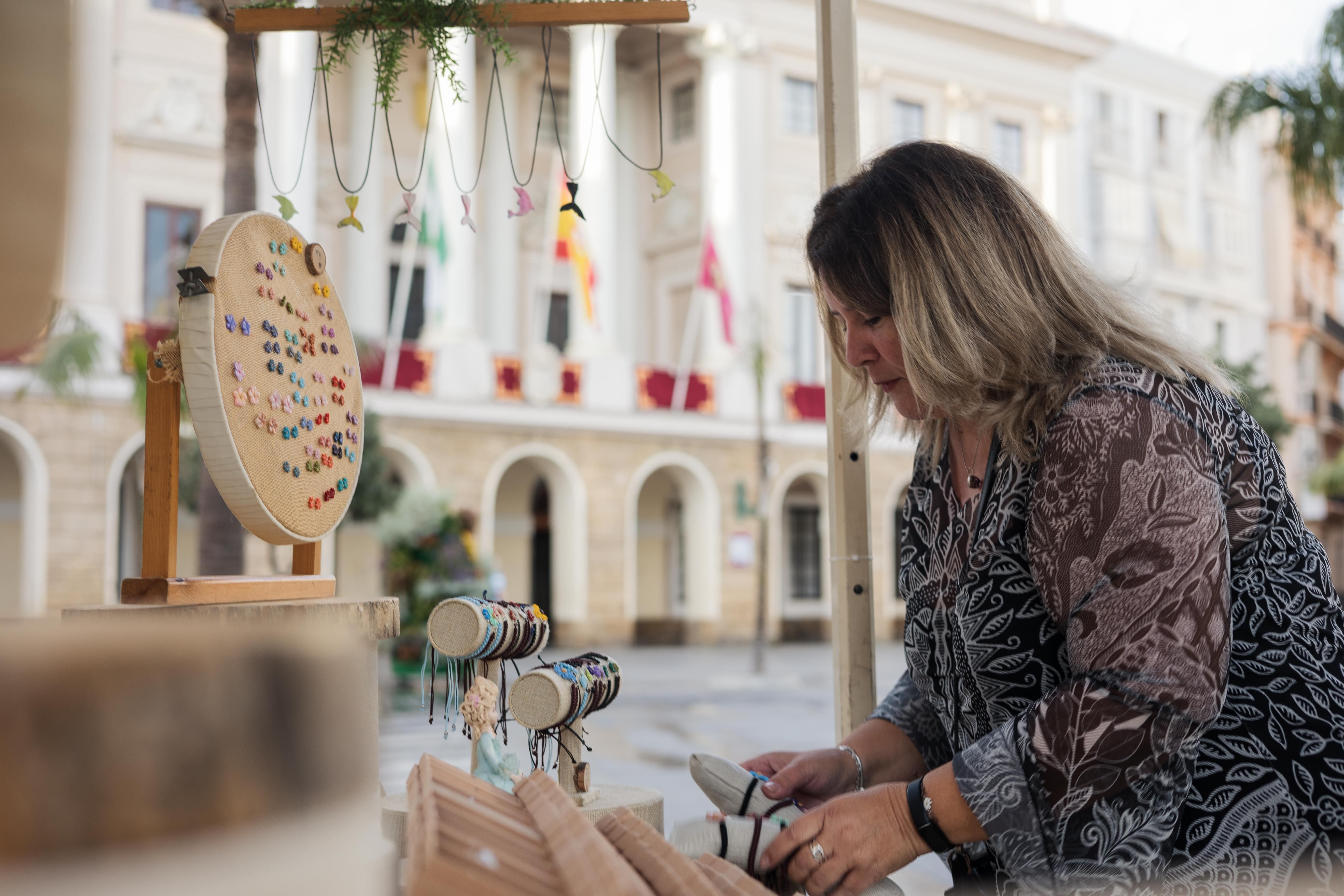 Adriana coloca sus piezas en el puesto ubicado frente al Ayuntamiento de Cádiz.