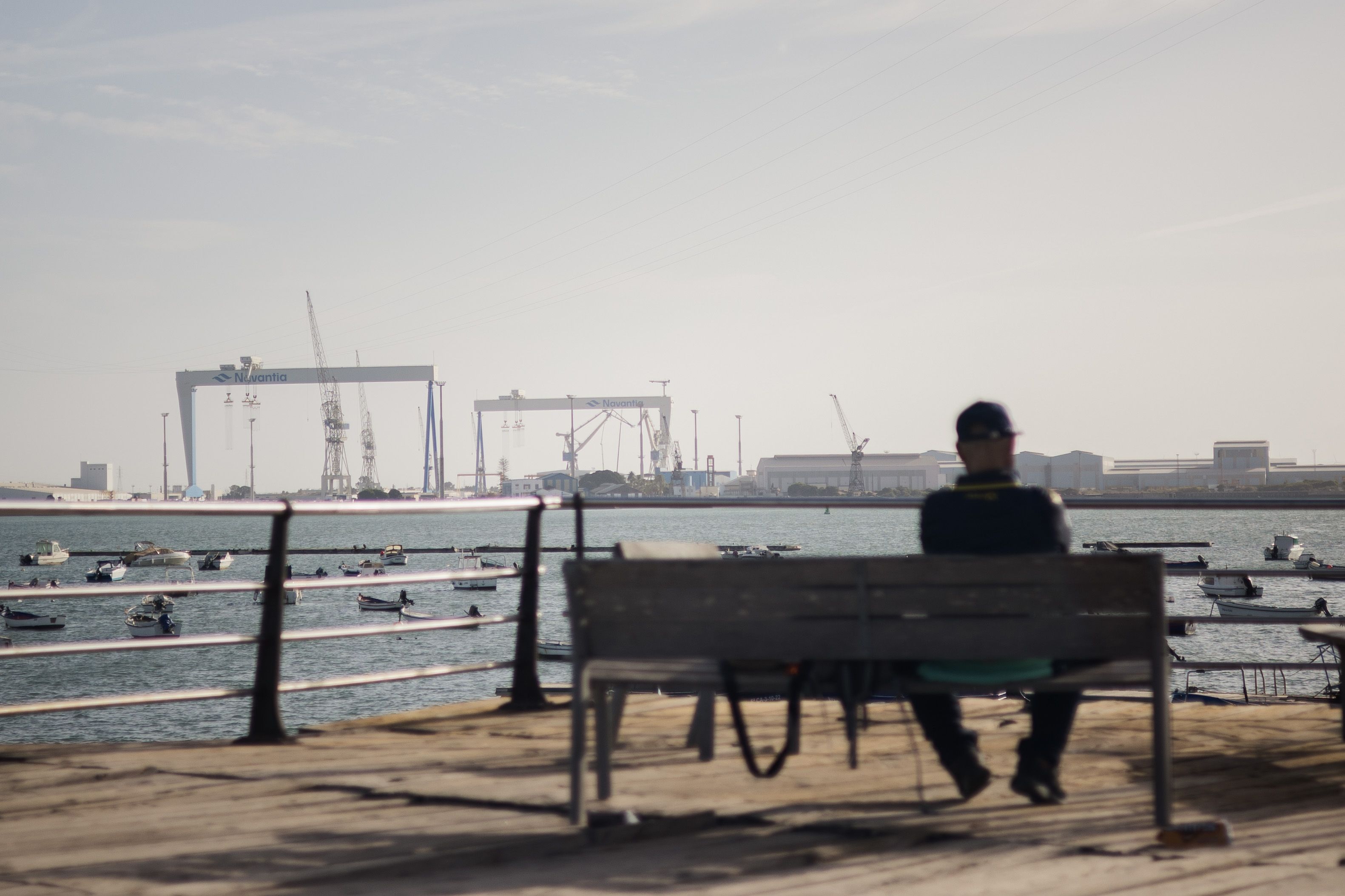 Un hombre observa desde Cádiz los astilleros de Navantia en Puerto Real.