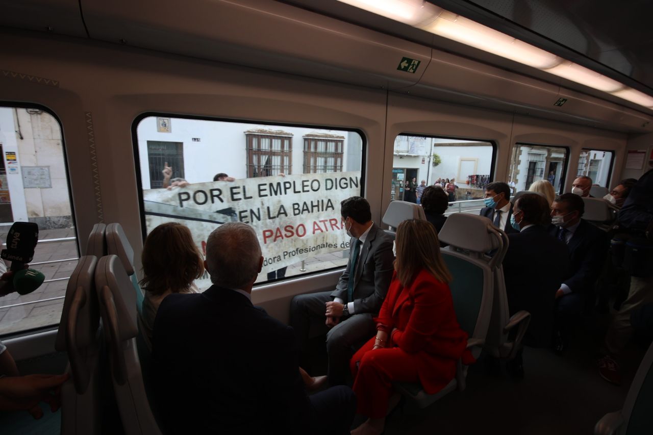 Moreno durante el viaje en tranvía mirando una pancarta que pide trabajo.