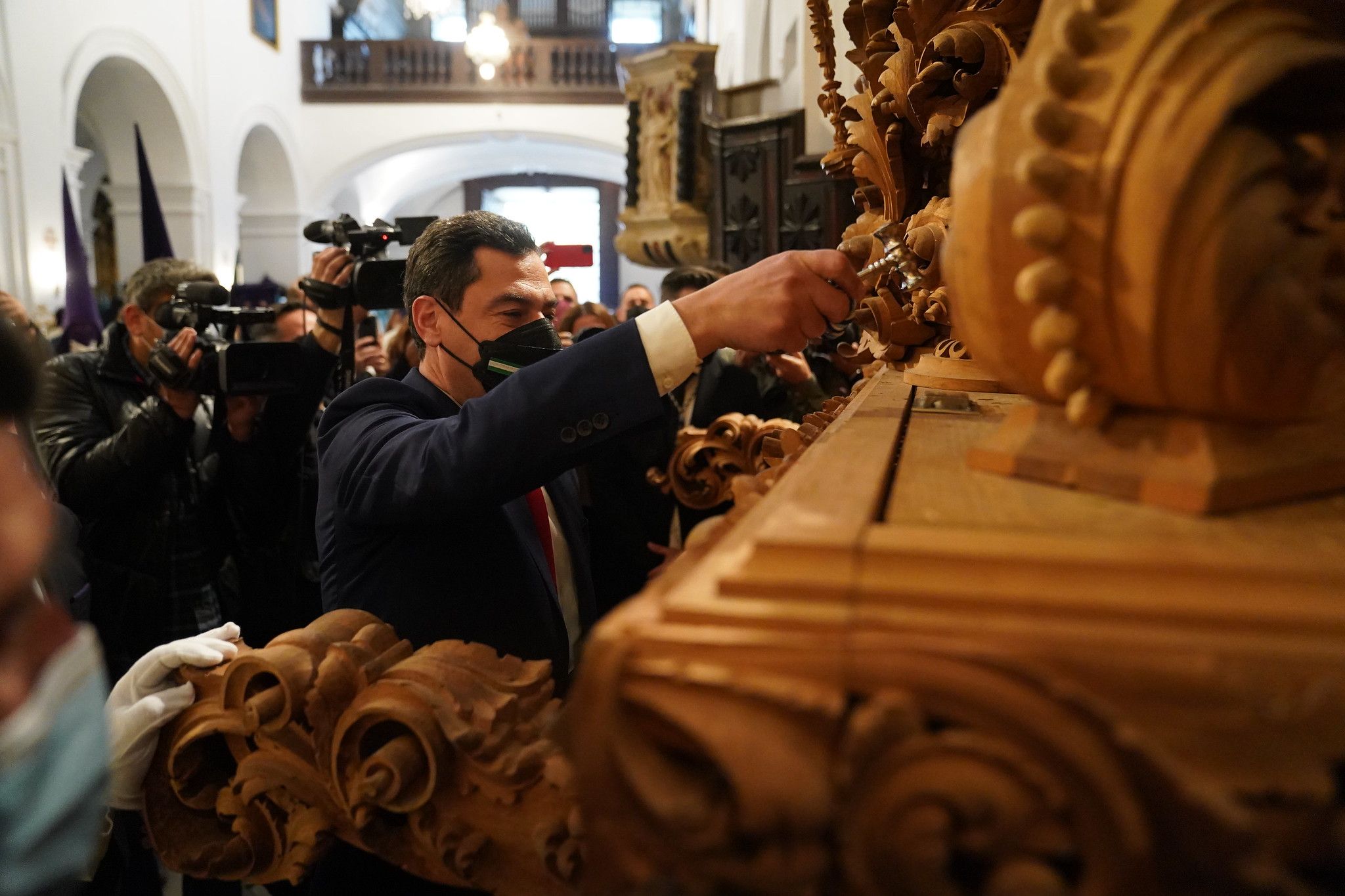 Juanma Moreno tocando el llamador de un paso la pasada Semana Santa.