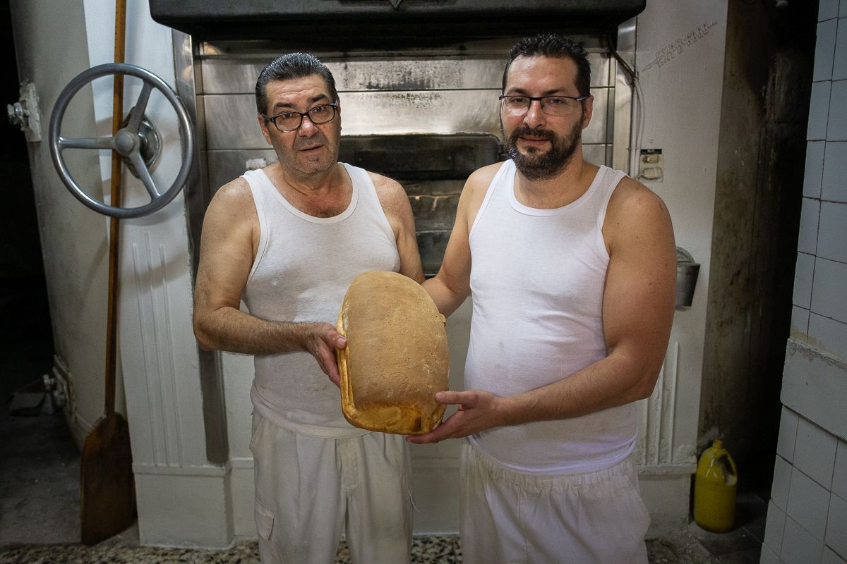Pedro Bazán y su hijo Juan sosteniendo una telera recién hecha. FOTO: MANU GARCÍA.