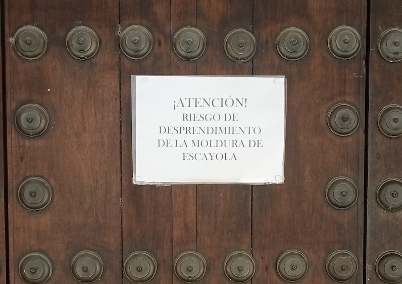 Cartel de aviso colocado en la puerta de acceso a la capilla.    J. Gutiérrez