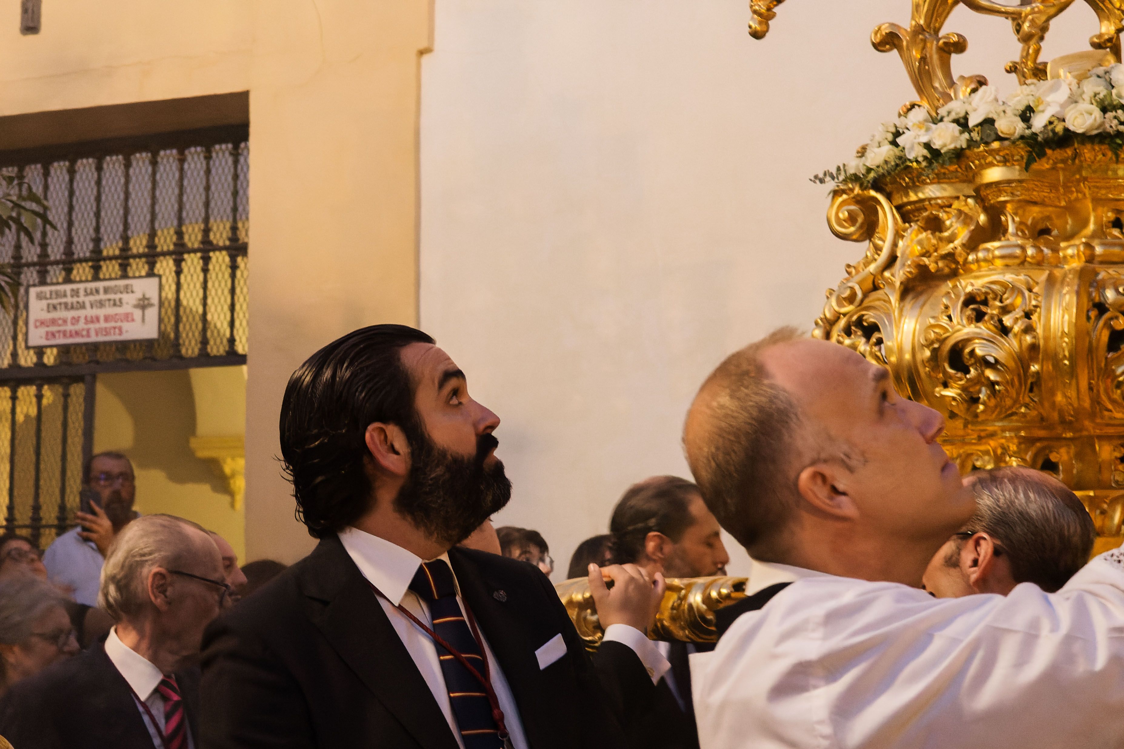 El encendedor afanándose para encender los candelabros pese al viento que sopló. 