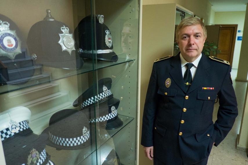 Javier Pérez Andrada, en la jefatura, junto a una vitrina donde se exponen gorras de policías locales de diferentes países. FOTO: Manu García