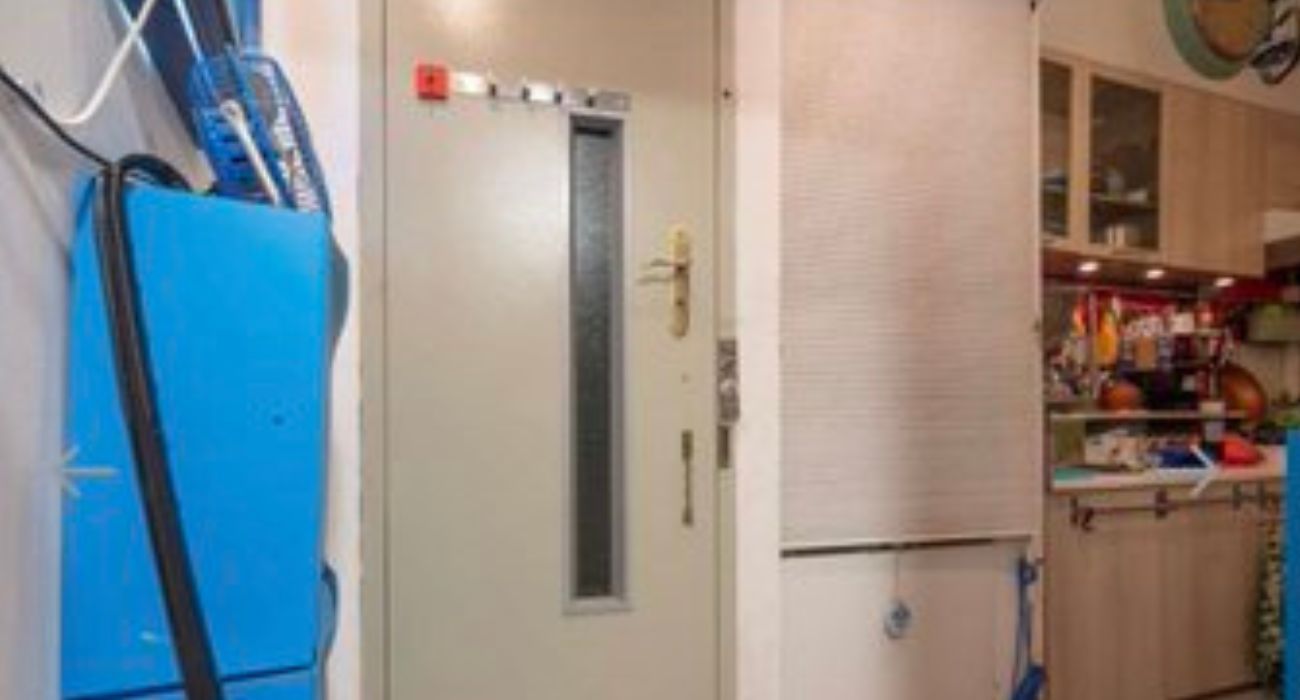 Ascensor, con perchero y cadena de seguridad, dentro de la cocina de un inmueble.