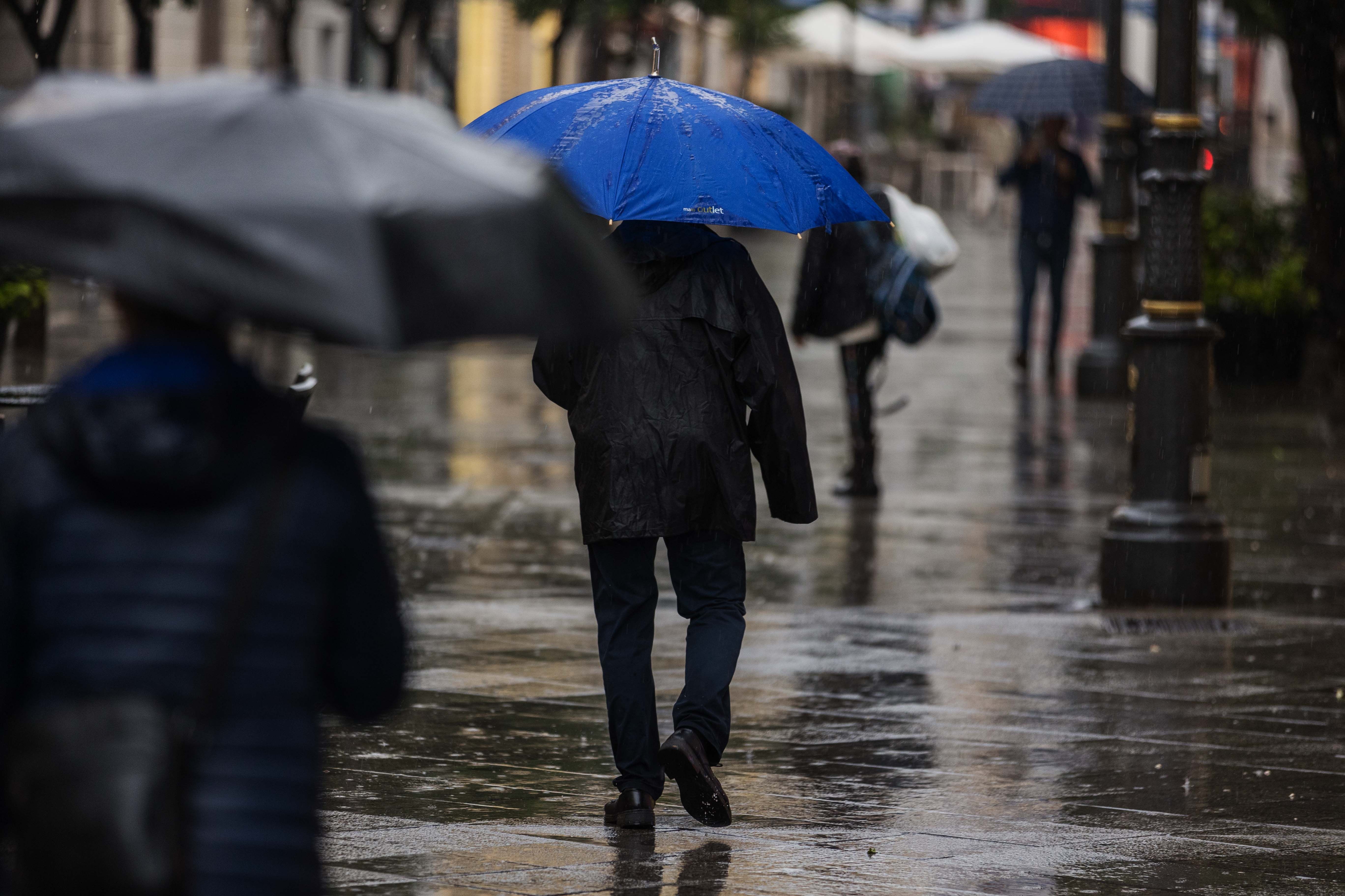 Varias personas pasean por Jerez en uno de los escasos días de lluvia recientes, causa de la falta de agua.