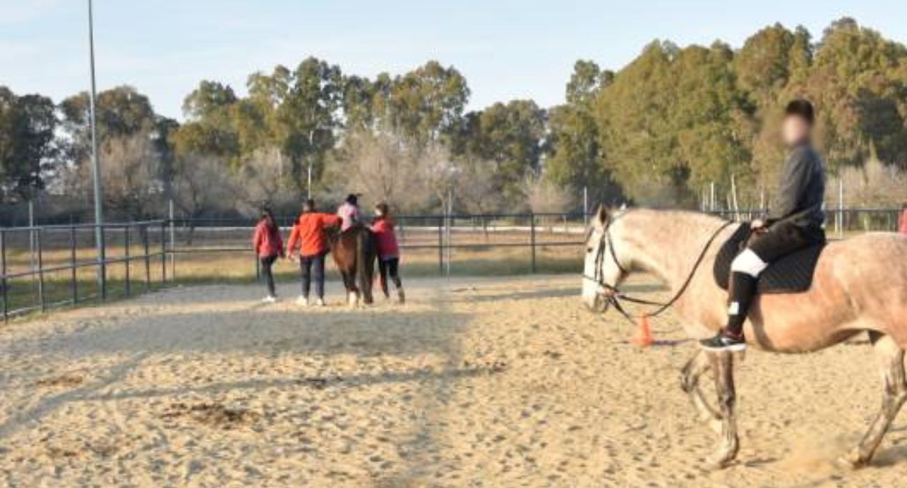 Alumnos montados a caballo en una clase de hipoterapia.