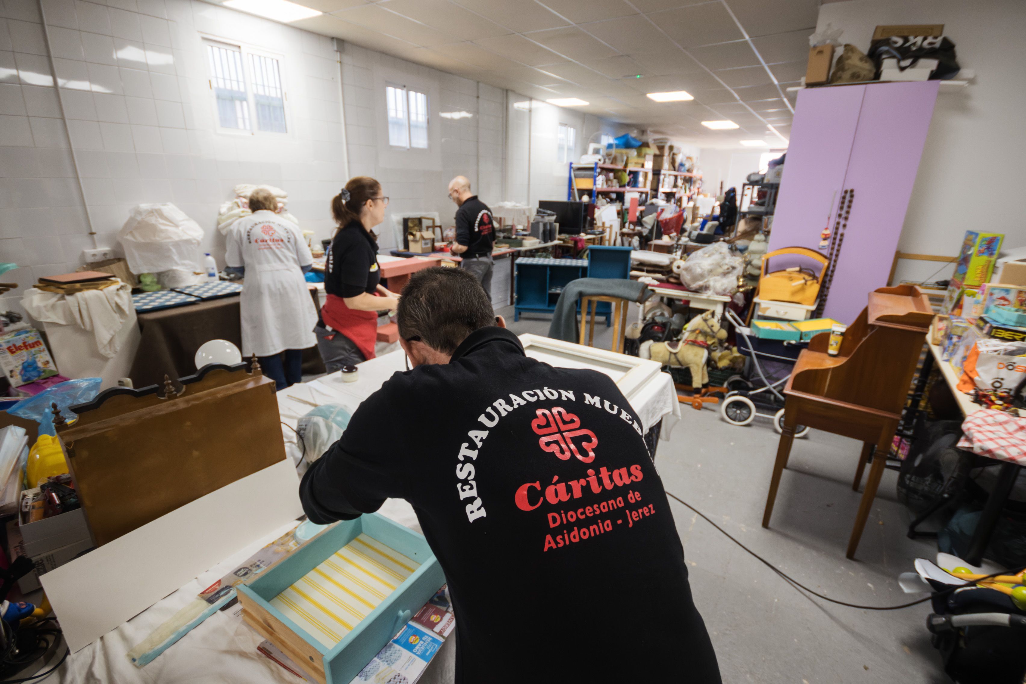 Empleados de Casa Común en las labores de confección y reparación de prendas.      MANU GARCIA