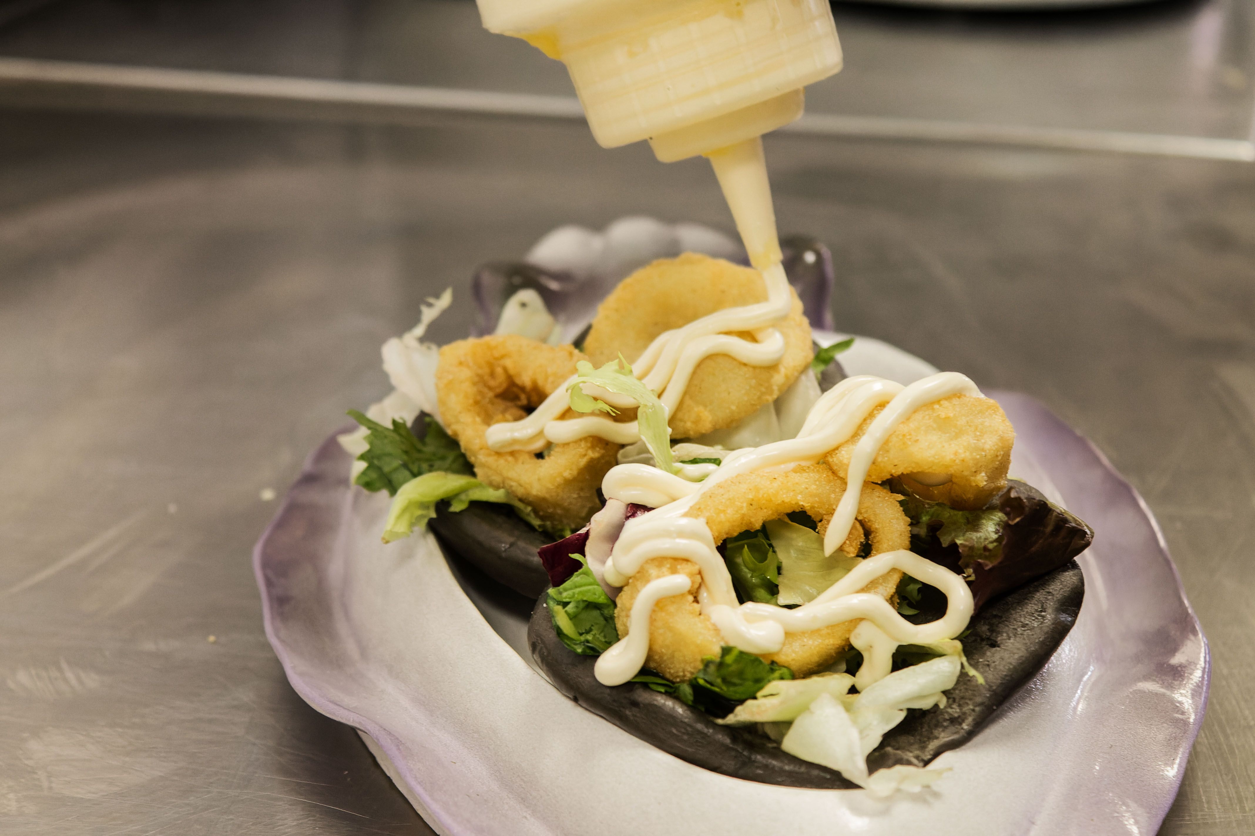 Inma termina el plato de pan bao con chocos fritos.