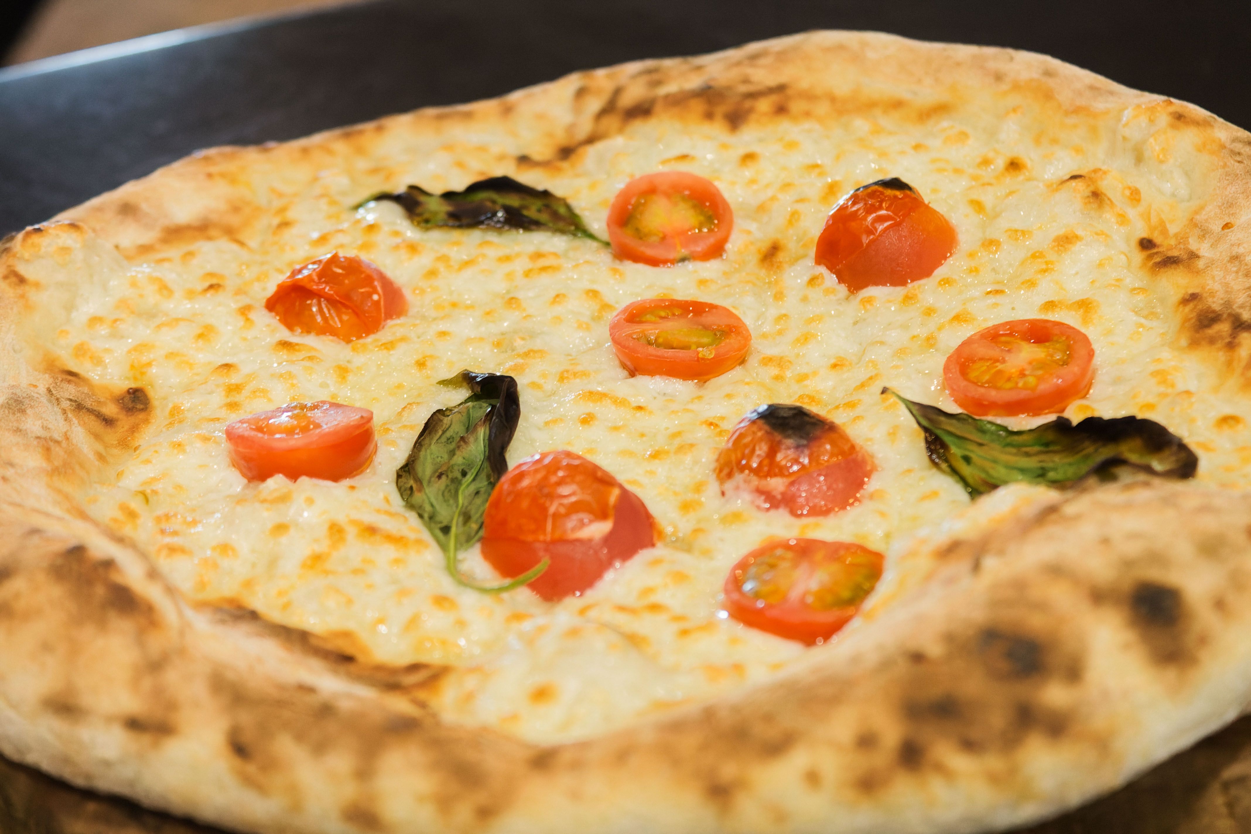 Una pizza recién horneada en el local.