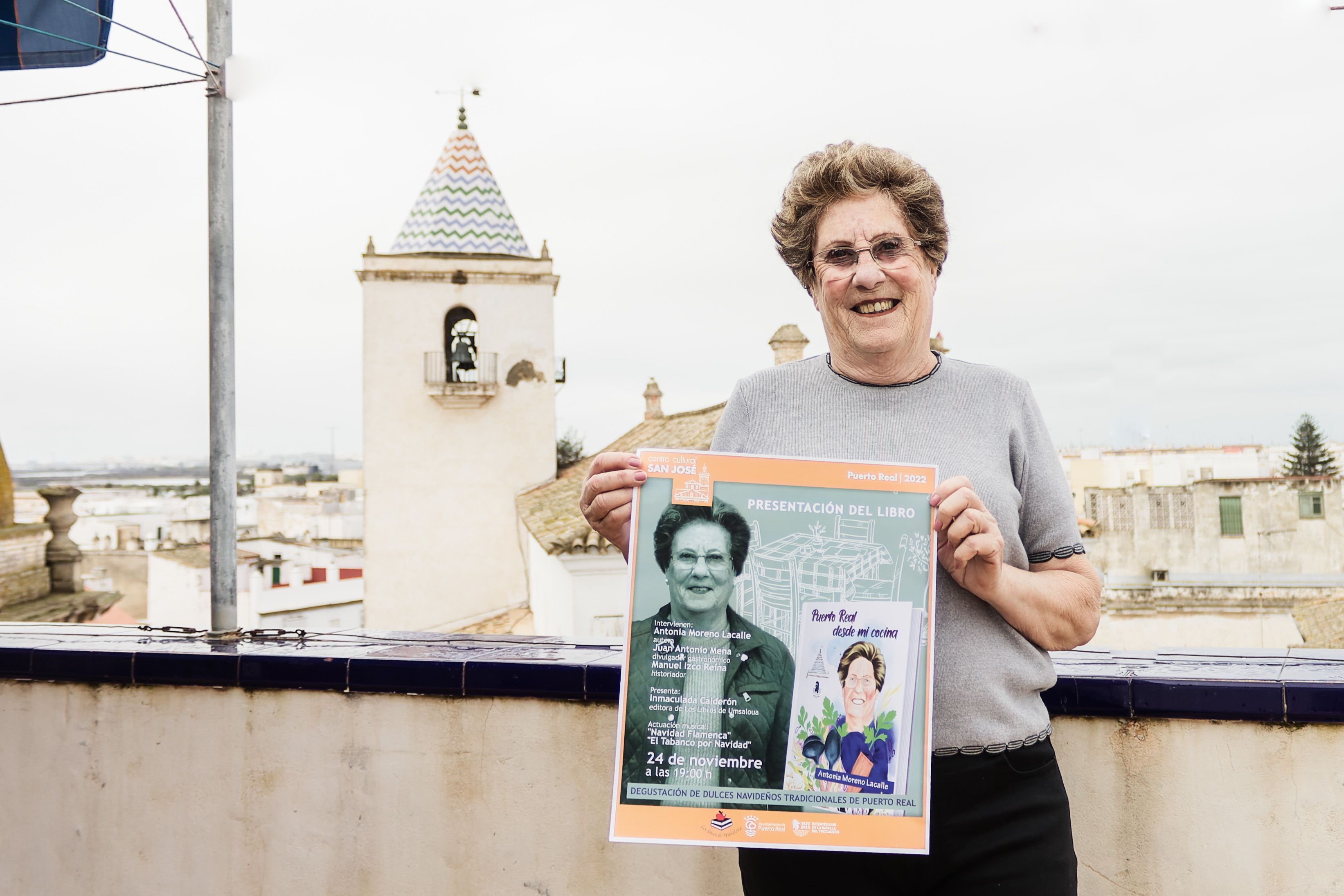 Antonia sujeta el cartel de la presentación de su libro. 