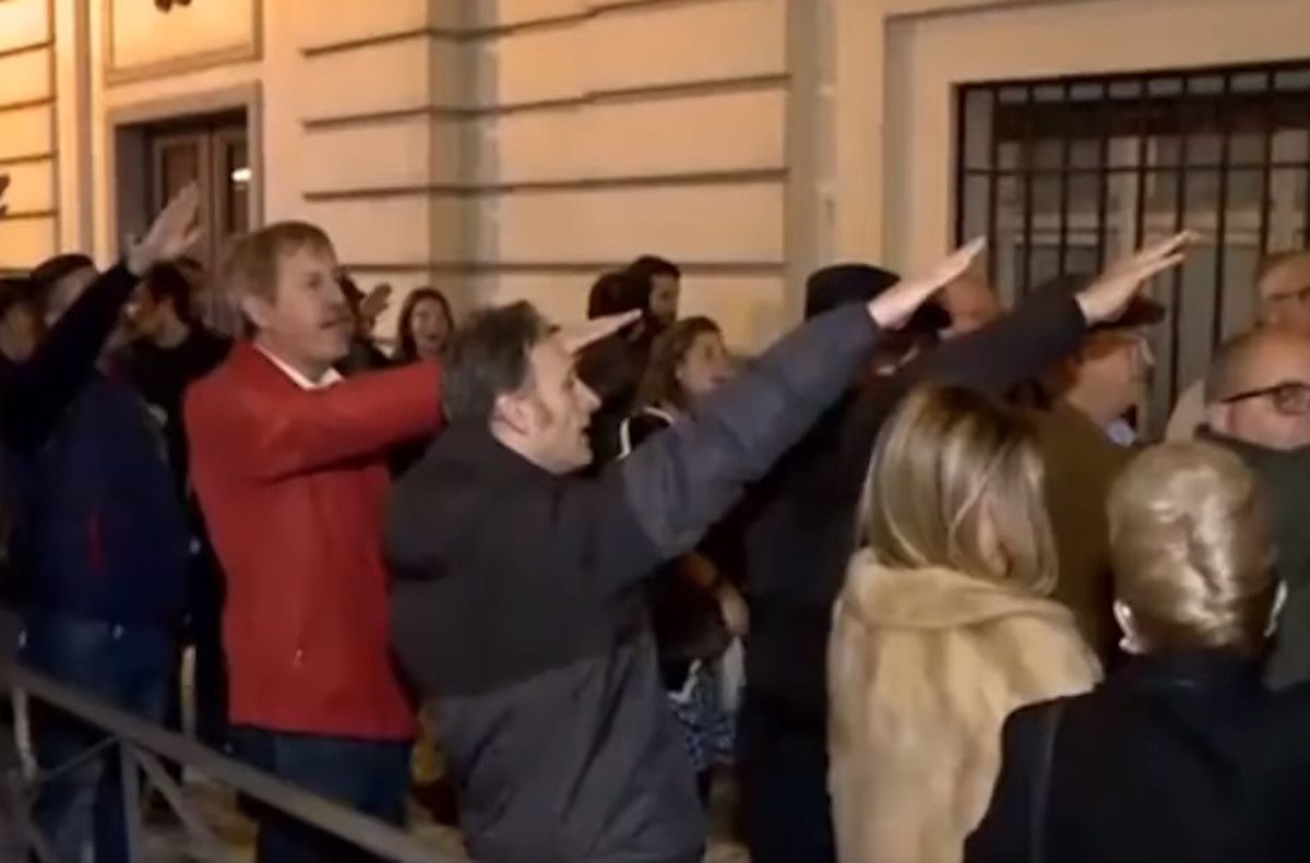 Un grupo de personas entonan Cara al Sol en la puerta de la iglesia de Santa Bárbara en Madrid.