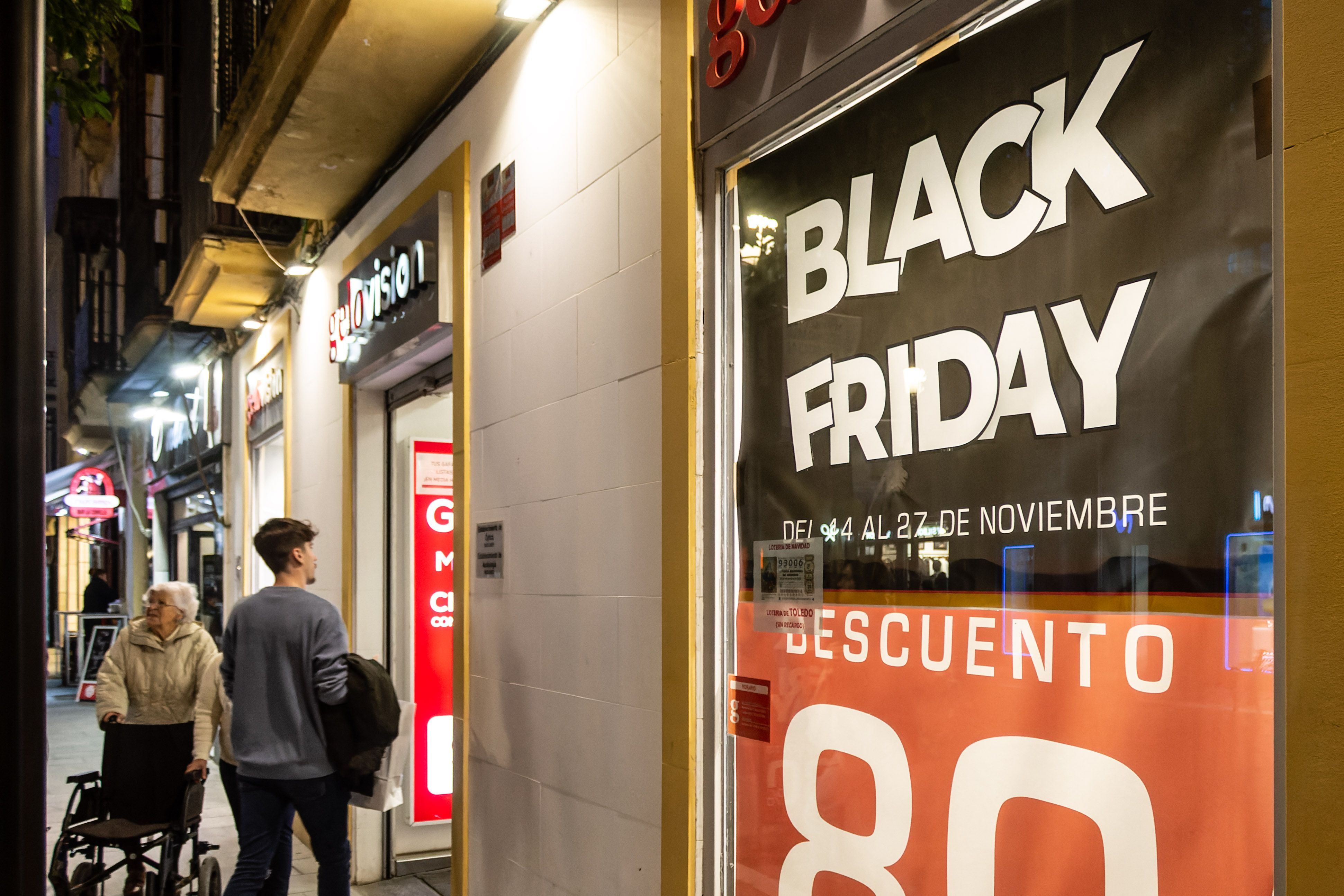 Varias personas pasan por tiendas con descuentos por el 'Black Friday'.
