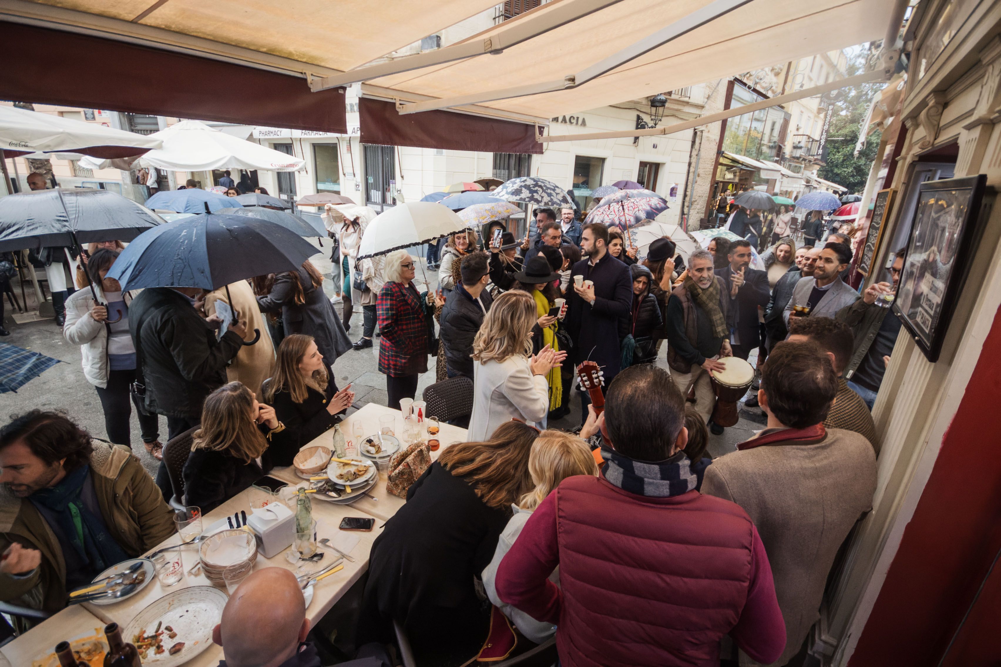 Cambios de ubicación y suspensiones de zambombas a causa de la lluvia. Paraguas abiertos en una en la calle este fin de semana.