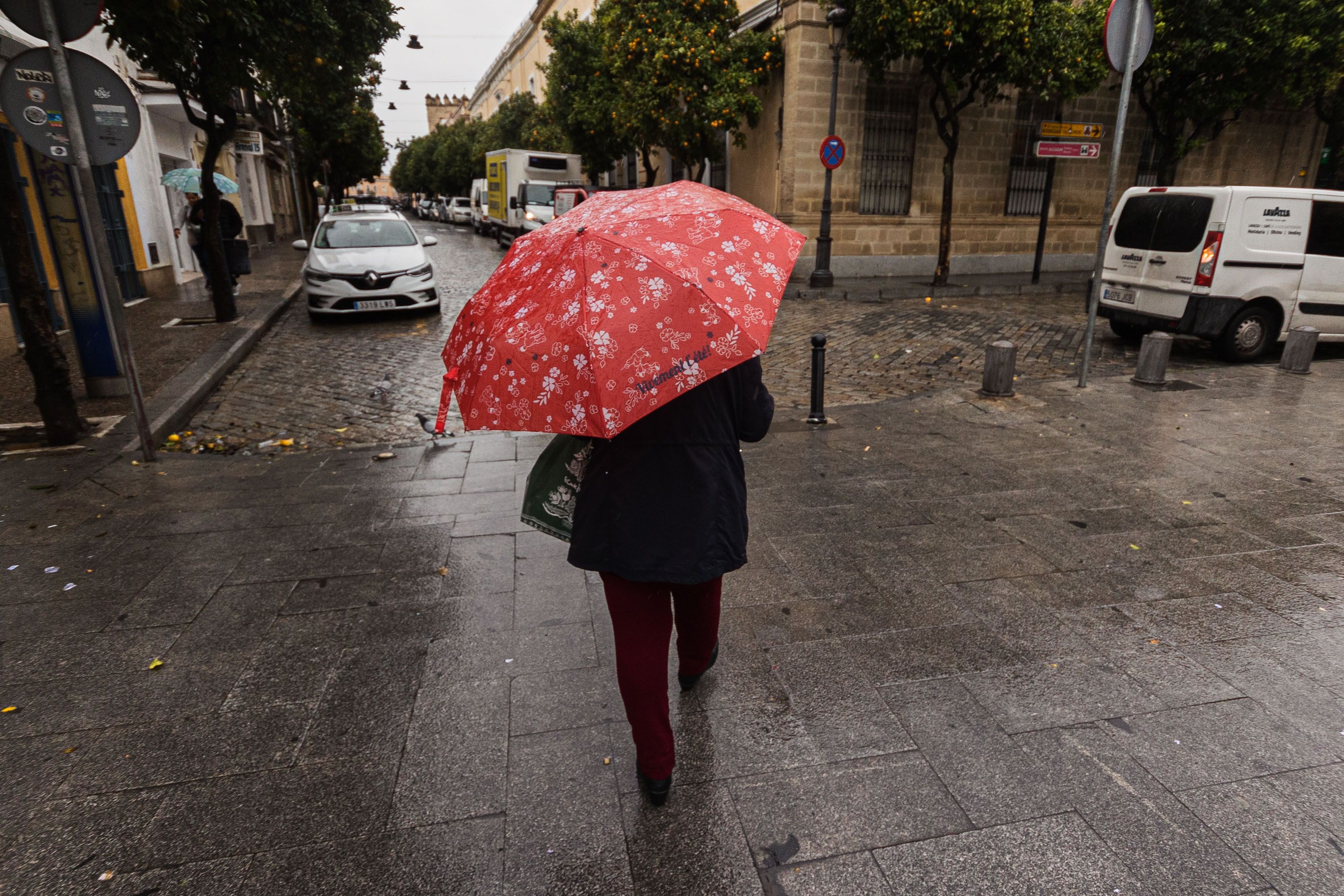 Una mujer se resguarda de las lluvias en una imagen de archivo.