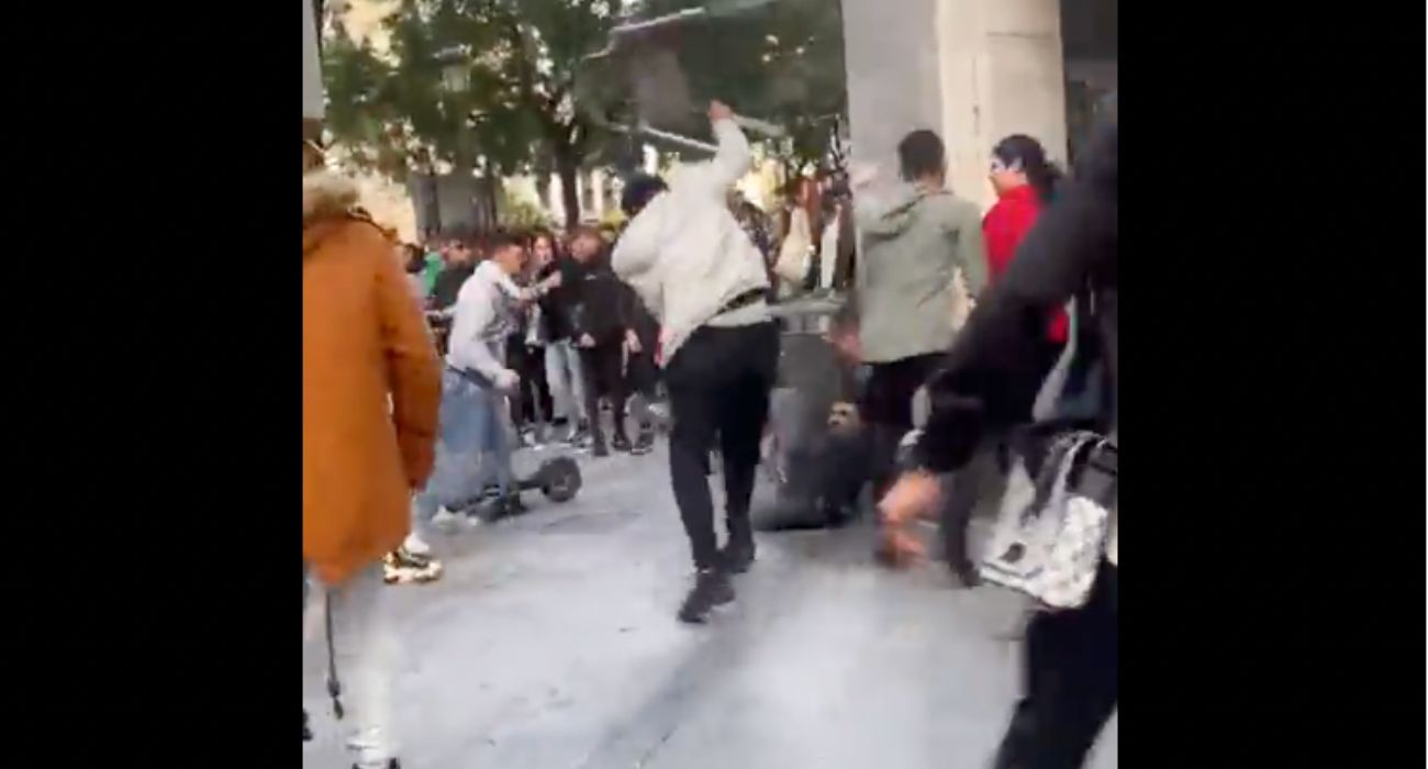 Un individuo lanza una silla contra otra persona que está en el suelo durante la batalla campal en Huelva entre aficionados de España y Marruecos.