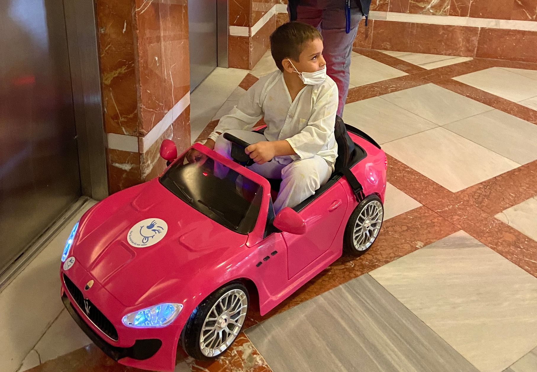 Un paciente infantil se desplaza en coche teledirigido en el Hospital de Puerto Real.