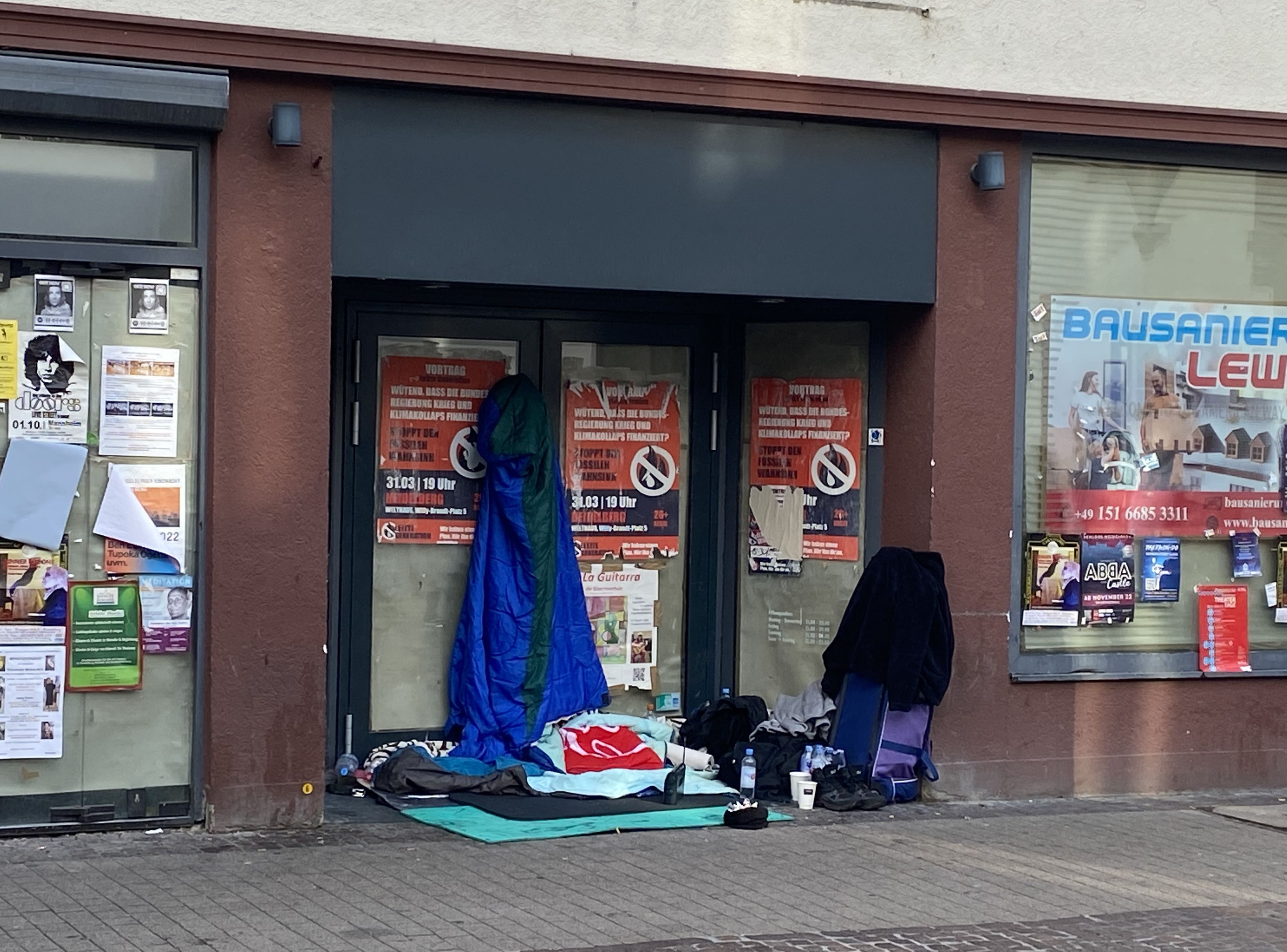 Vivienda improvisada en la entrada de una tienda cerrada por quiebra. PabloMtnezCalleja, 2022