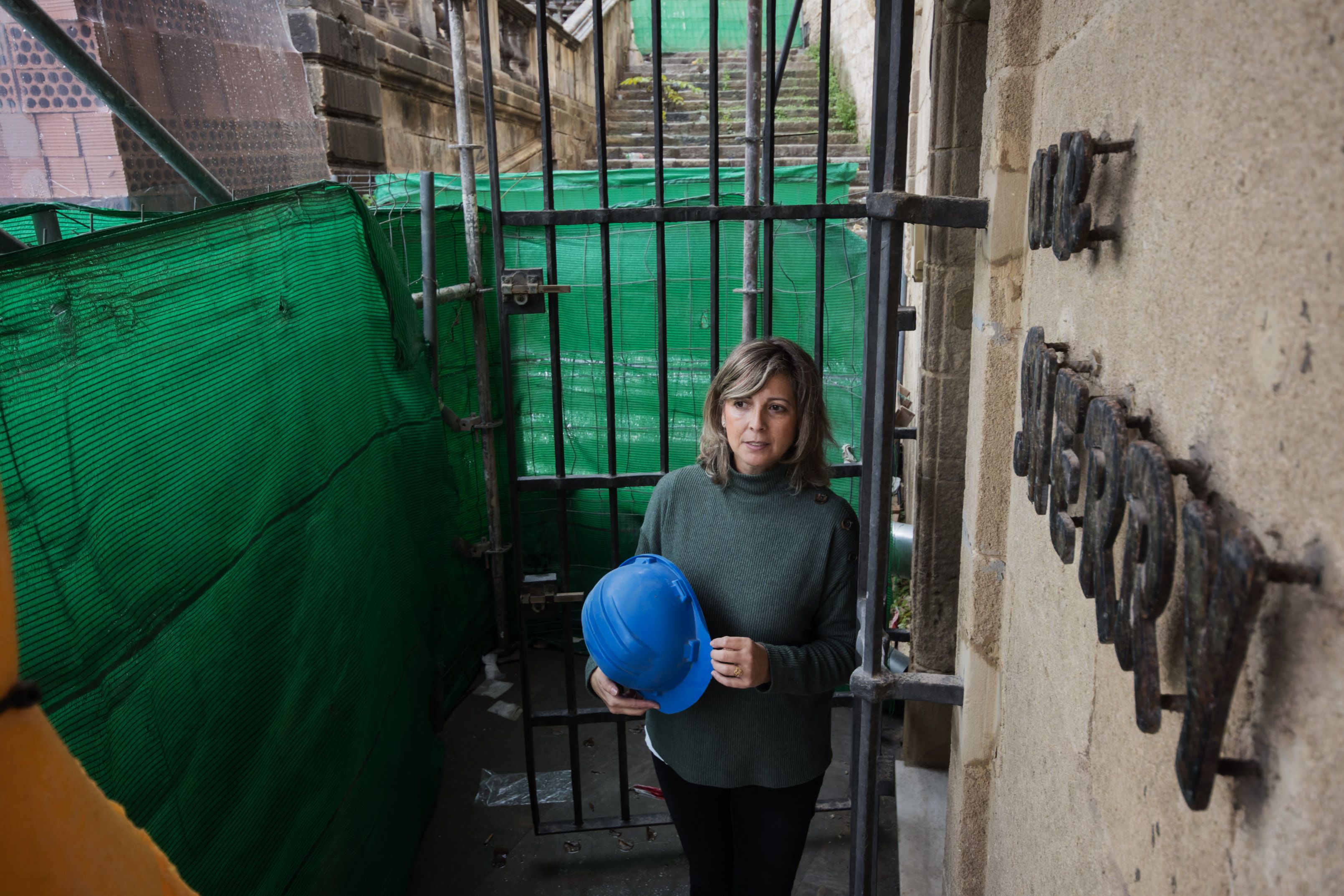 Un negocio de Jerez con más de 30 años ‘vive’ dentro de una obra de un nuevo hotel en el centro. La empleada de Arte Sherry en el túnel que da acceso a la oficina.