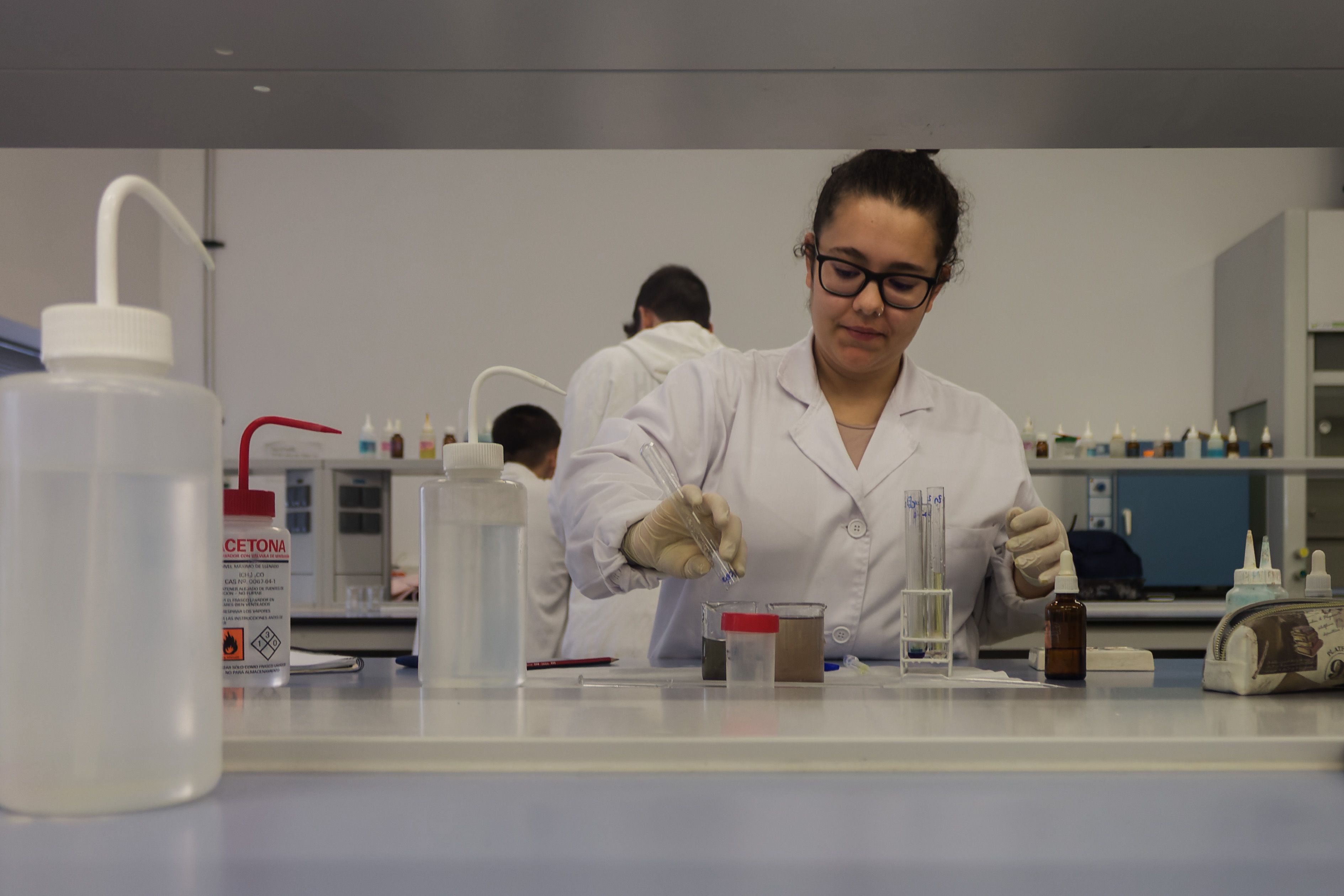 Una alumna realiza la práctica de Química Analítica en el laboratorio.