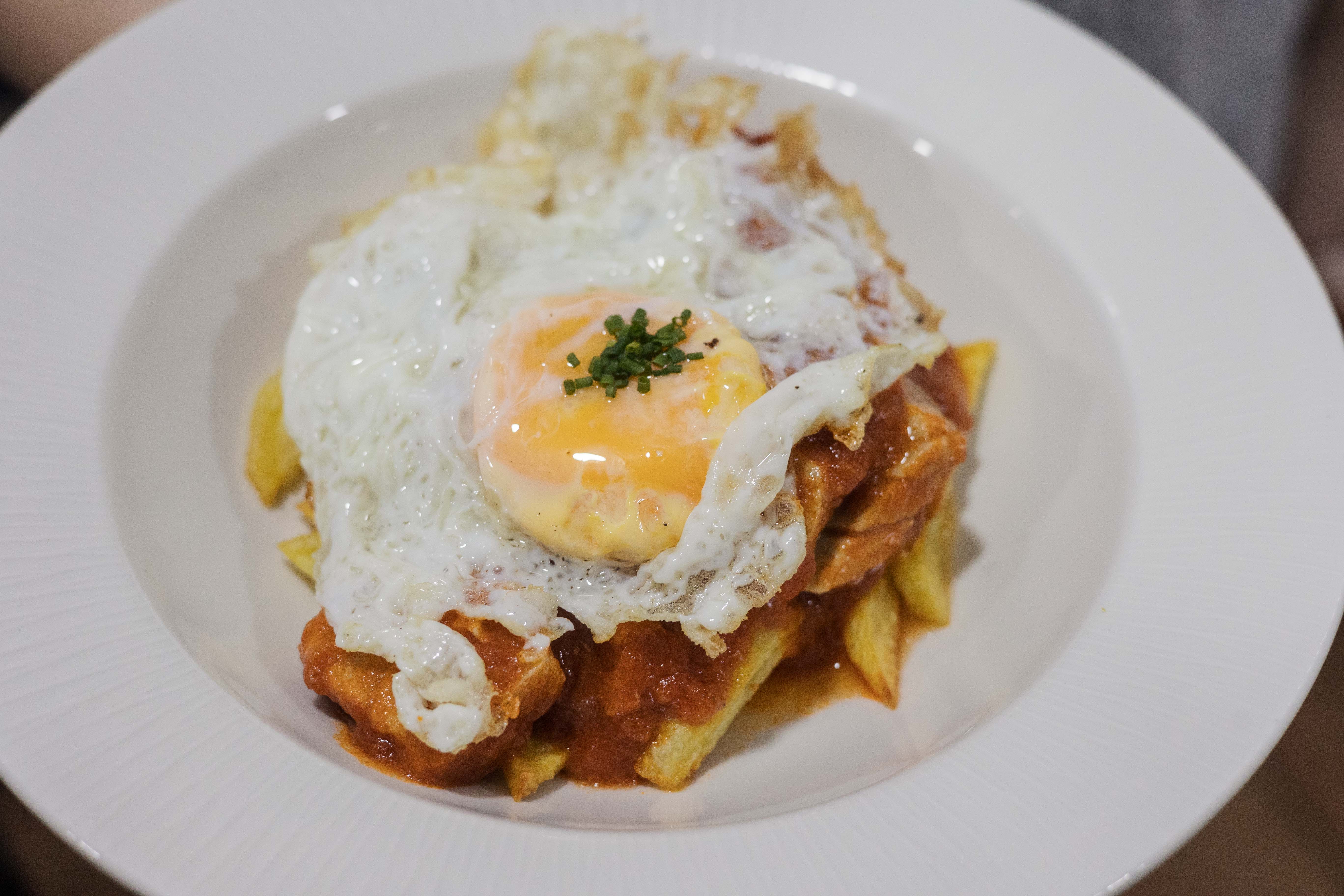 Atún en tomate con patatas y huevo fritos.