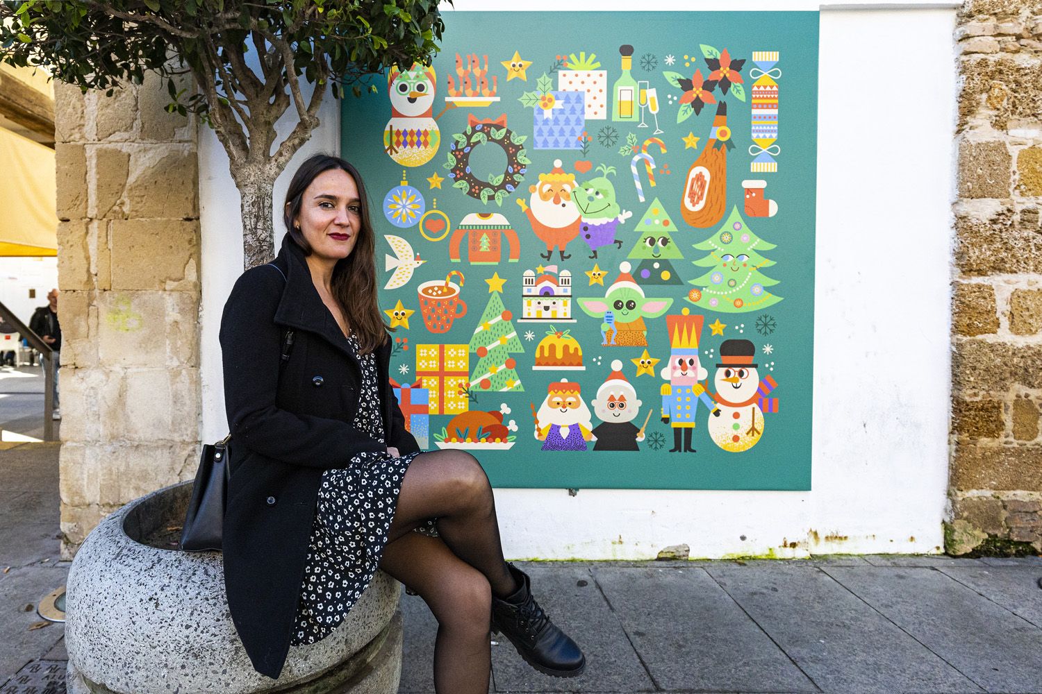 Raquel Jove fotografiada, en días pasados, junto a uno de los murales, obra suya, en el mercado de abastos de Cádiz.