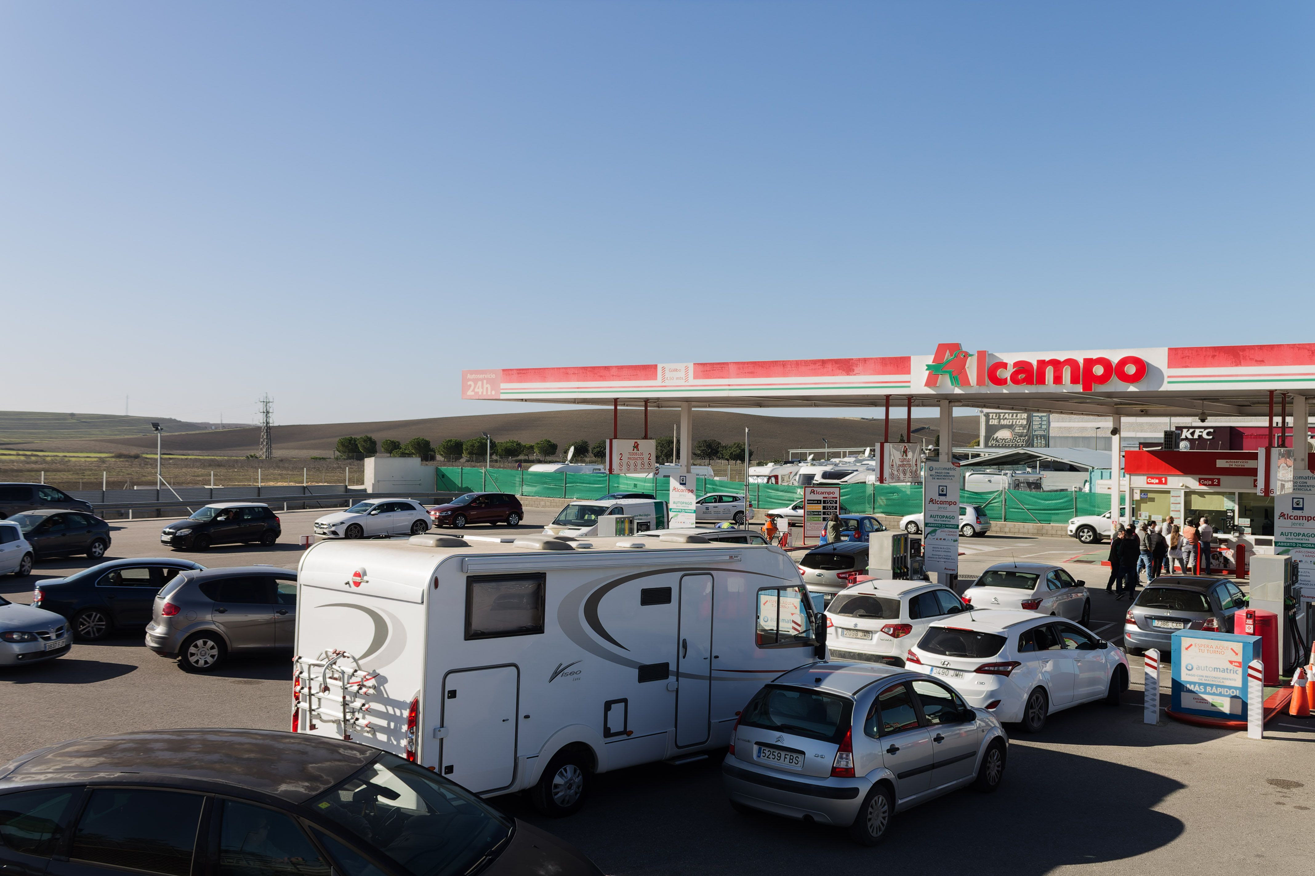 Conductores repostando en una gasolinera.