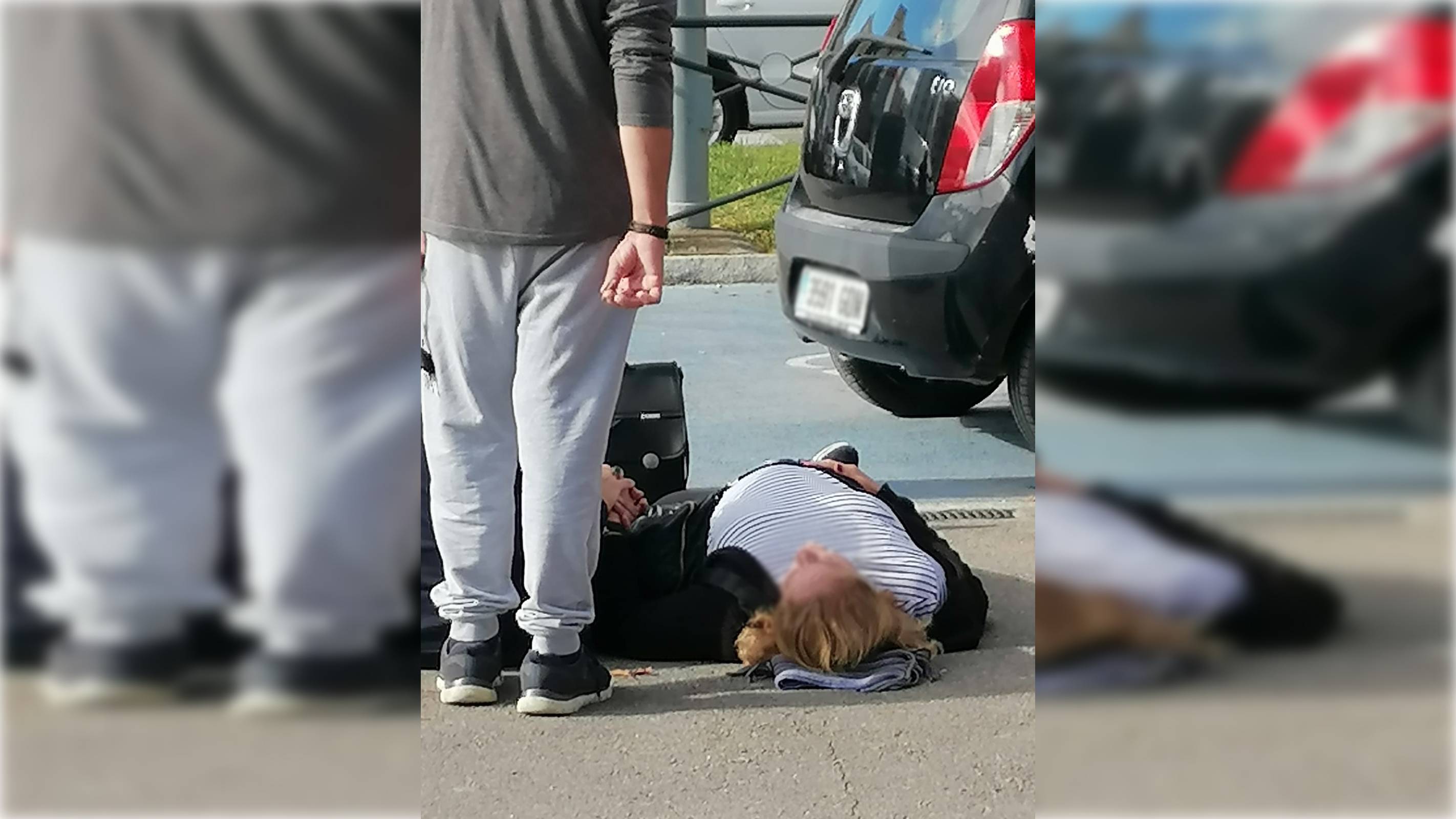La mujer, tirada en el suelo, esperando una ambulancia.